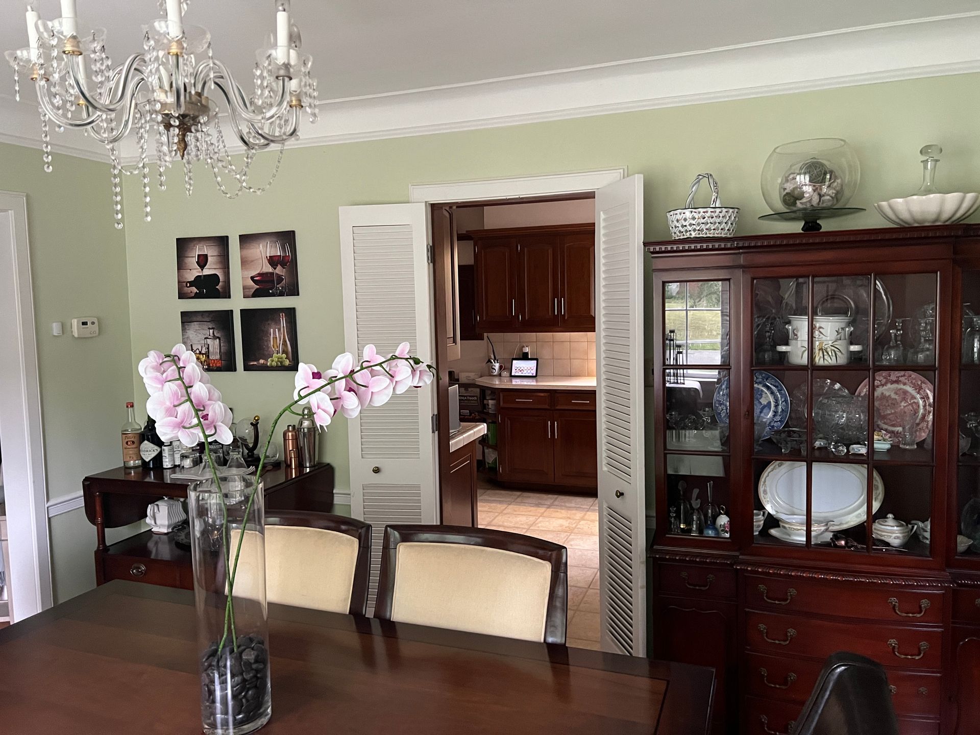 A dining room with a vase of flowers on the table