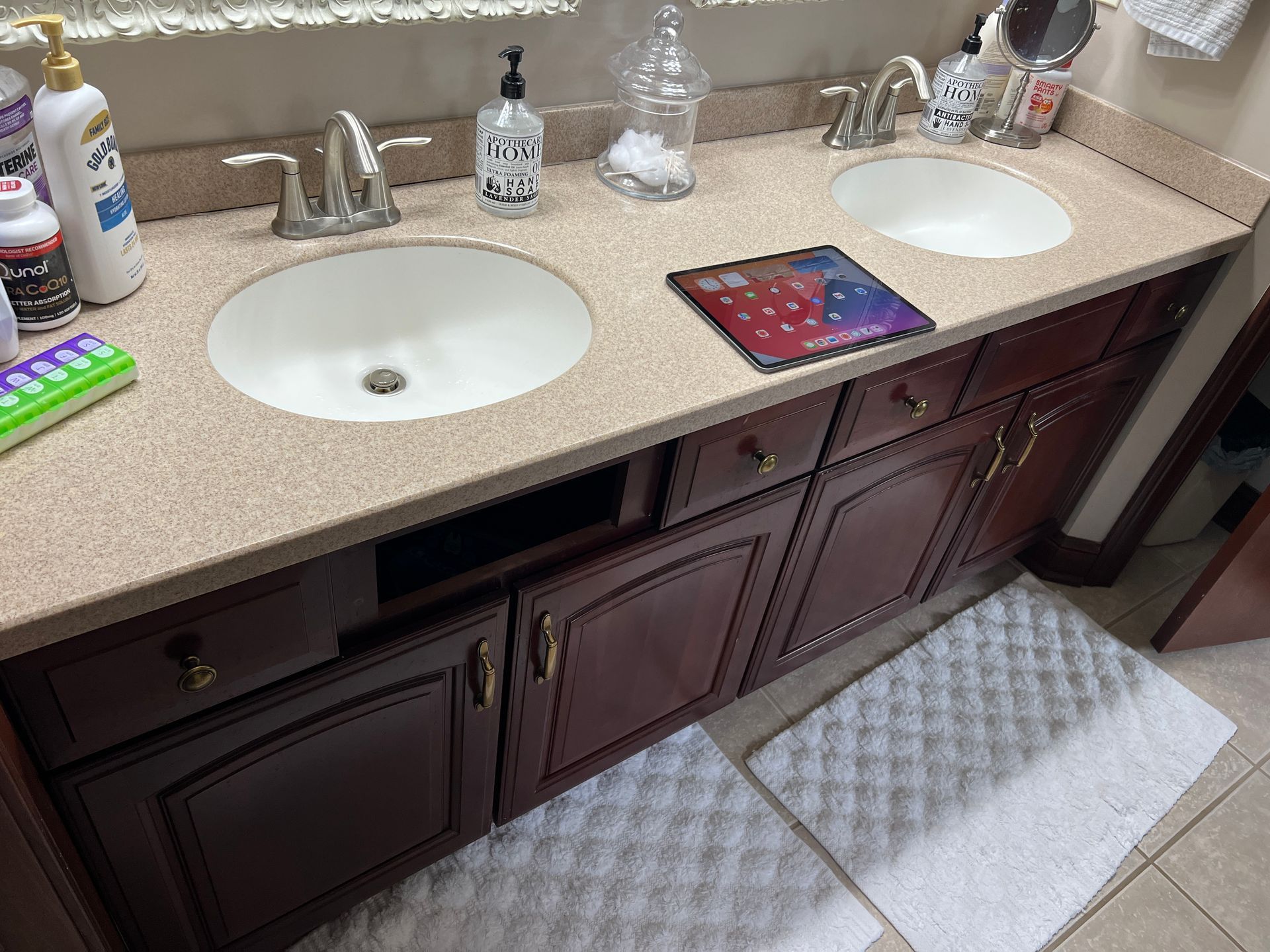 A bathroom with two sinks and a rug on the floor.