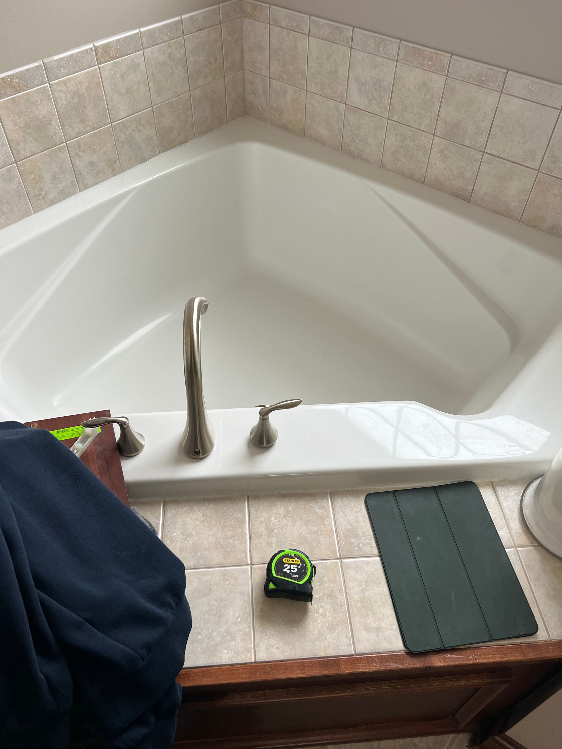 A person is measuring a bathtub with a tape measure.