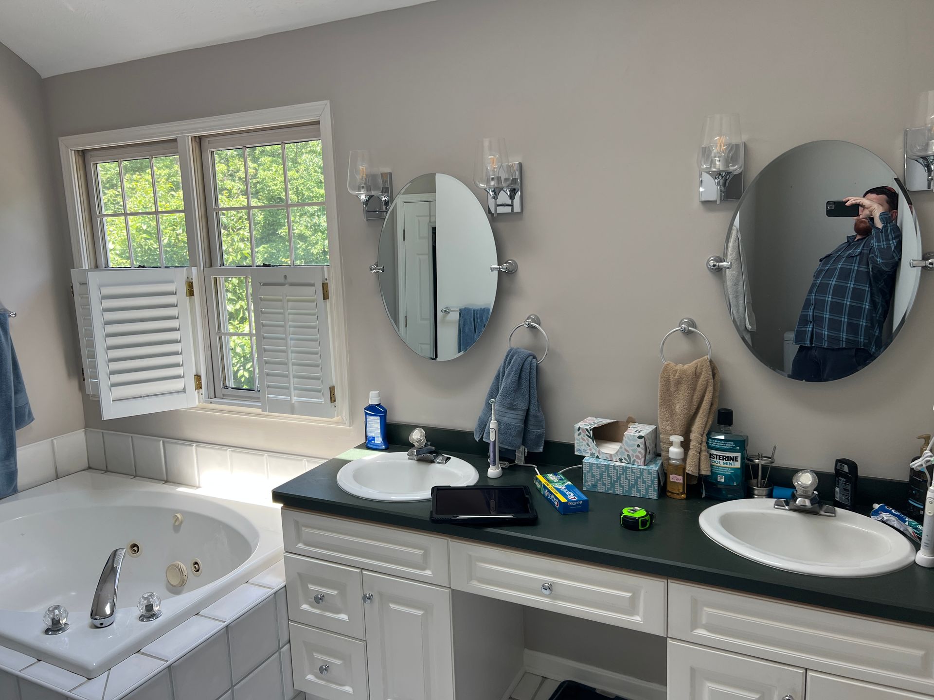 A man is taking a picture of his reflection in a bathroom mirror.