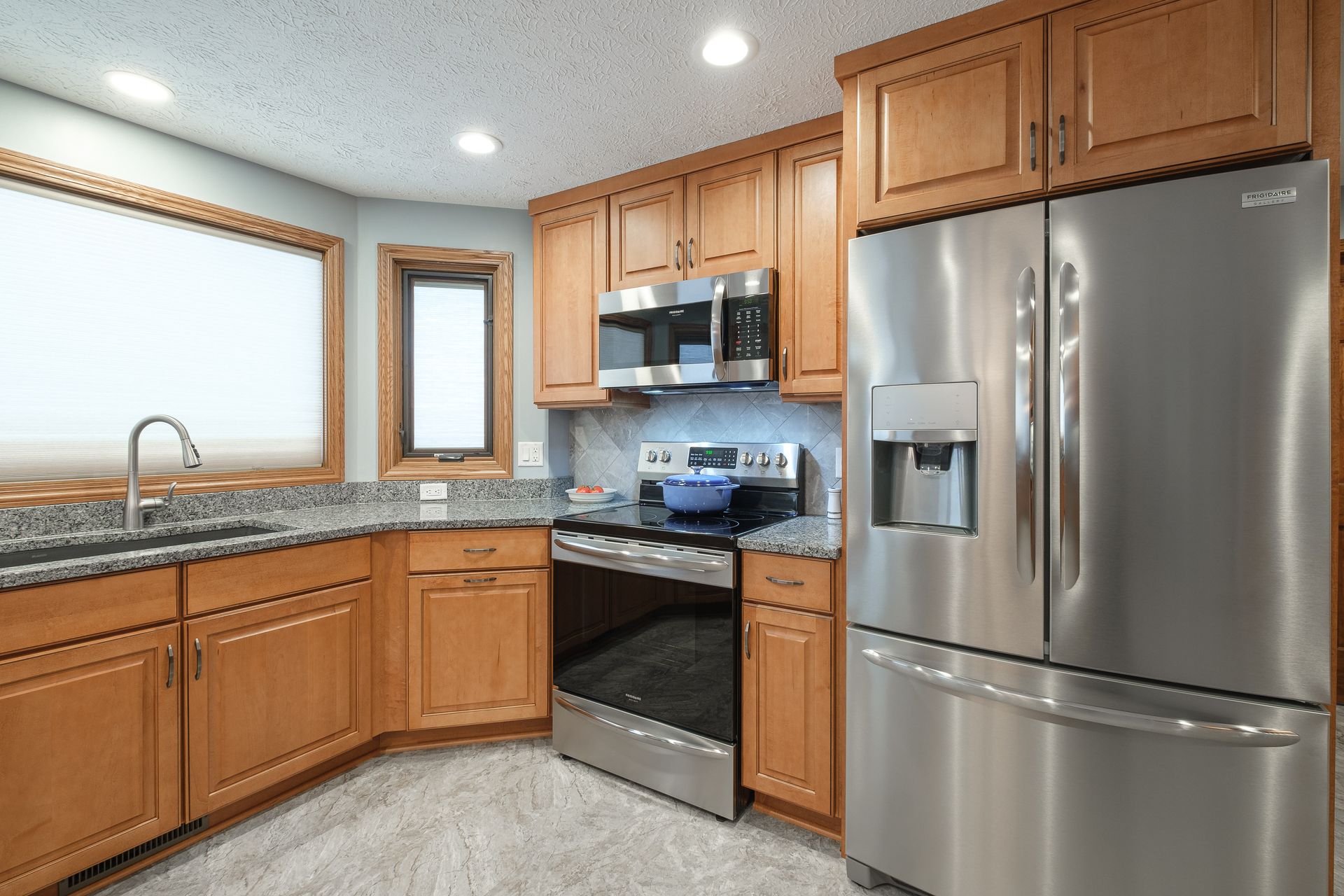 A kitchen with stainless steel appliances and wooden cabinets