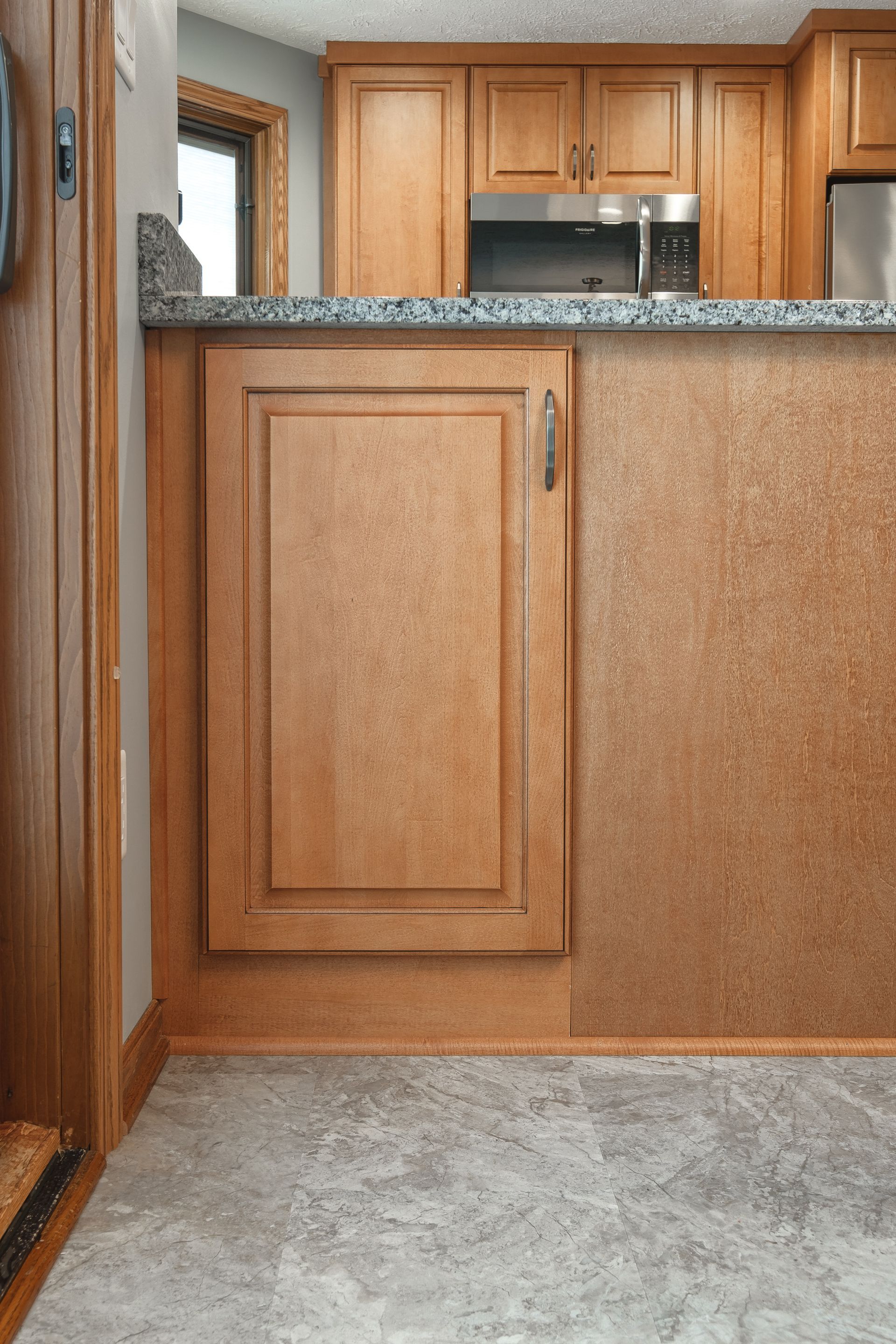 A kitchen with wooden cabinets and granite counter tops