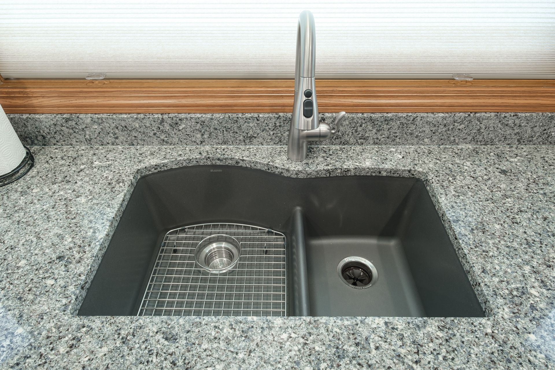 A kitchen sink is sitting on a granite counter top