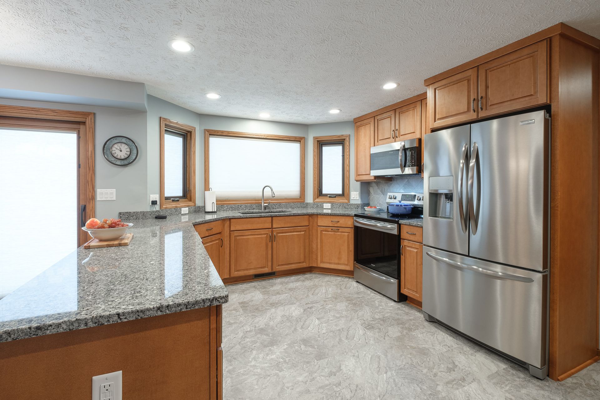 A kitchen with stainless steel appliances and granite counter tops.