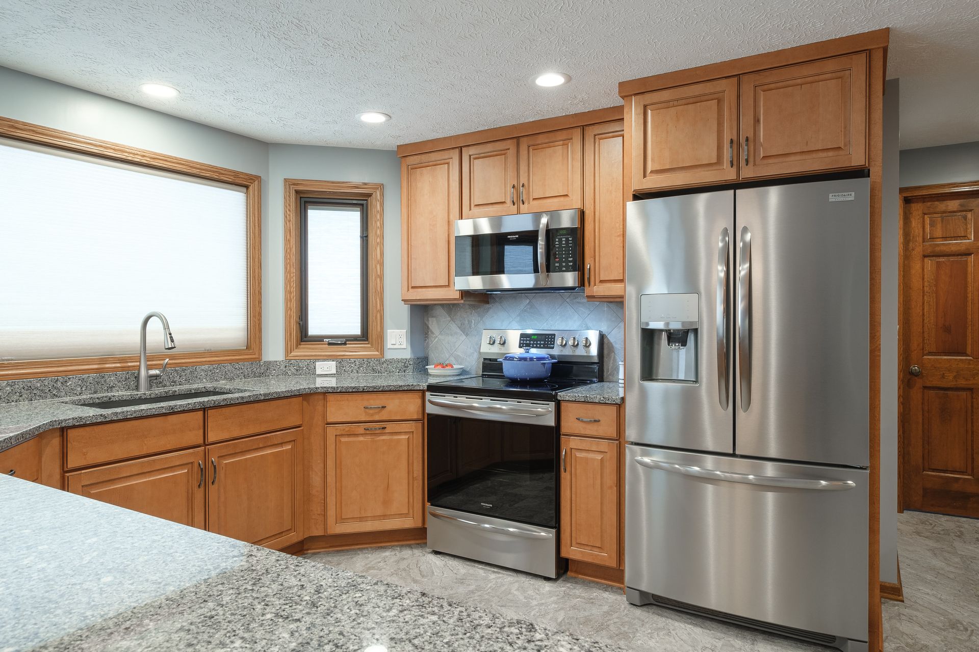 A kitchen with stainless steel appliances and wooden cabinets