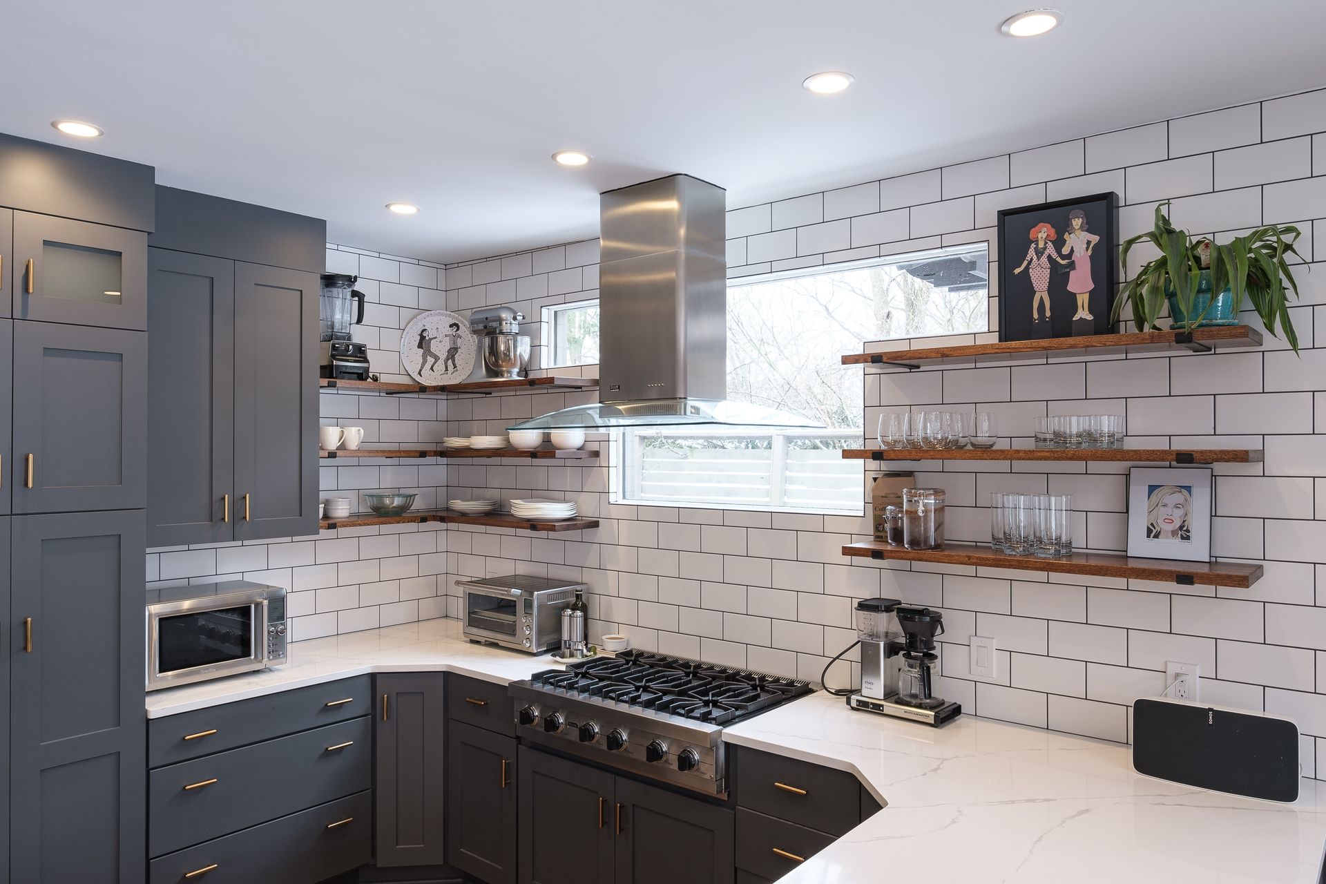 A kitchen with gray cabinets and white counter tops