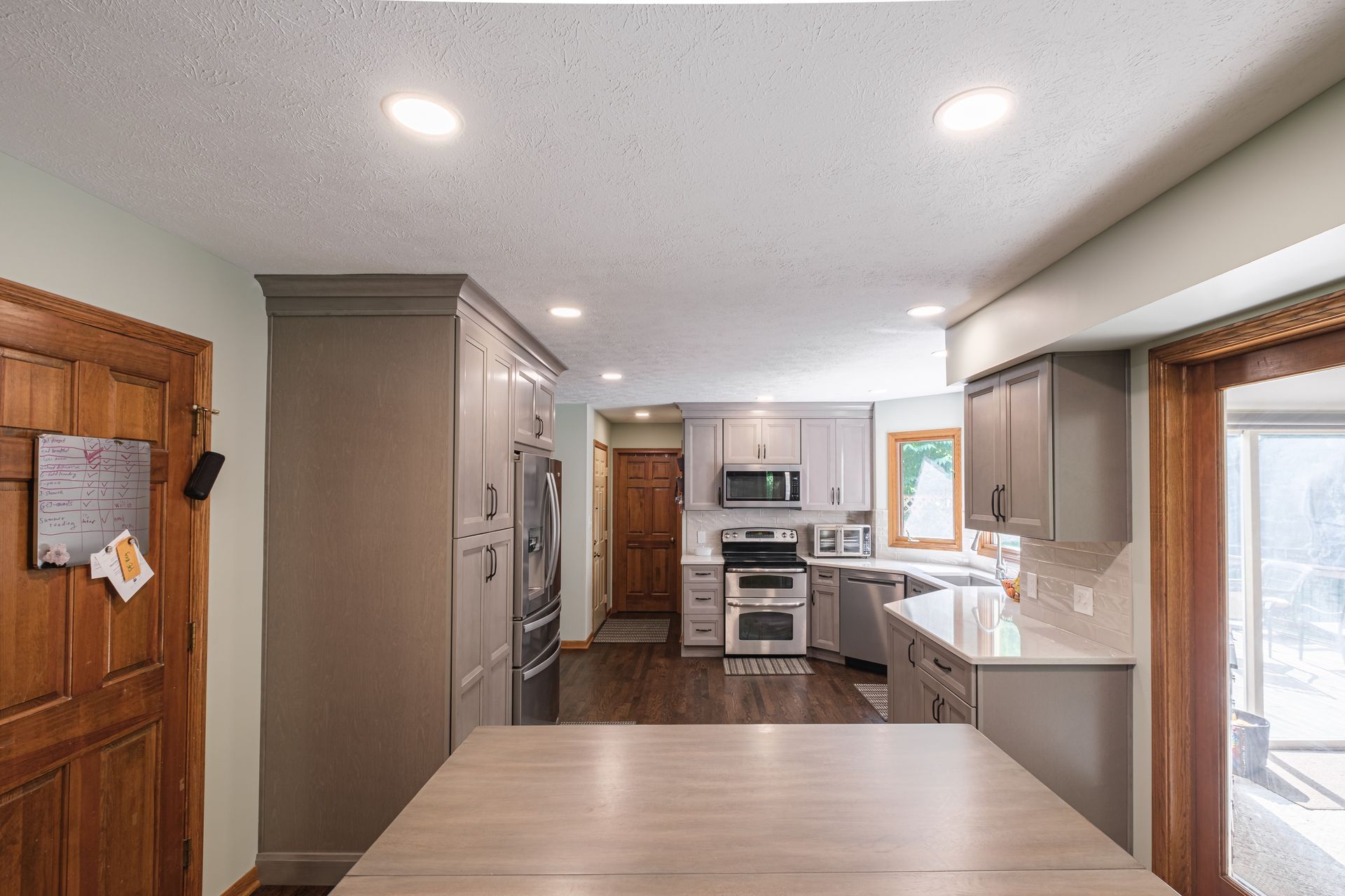 A kitchen with a table in the middle of it and a large window.