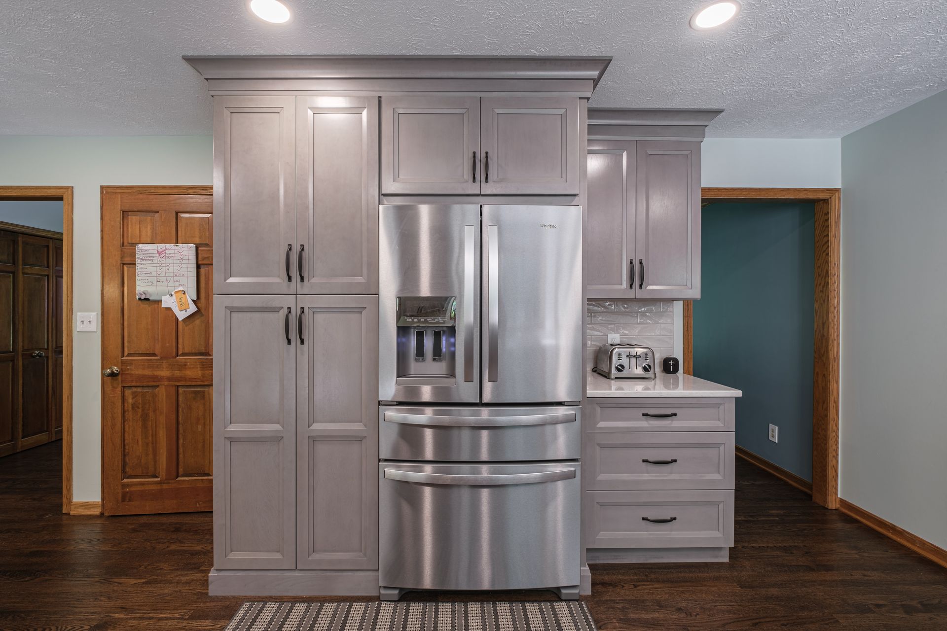 A kitchen with stainless steel appliances and gray cabinets.