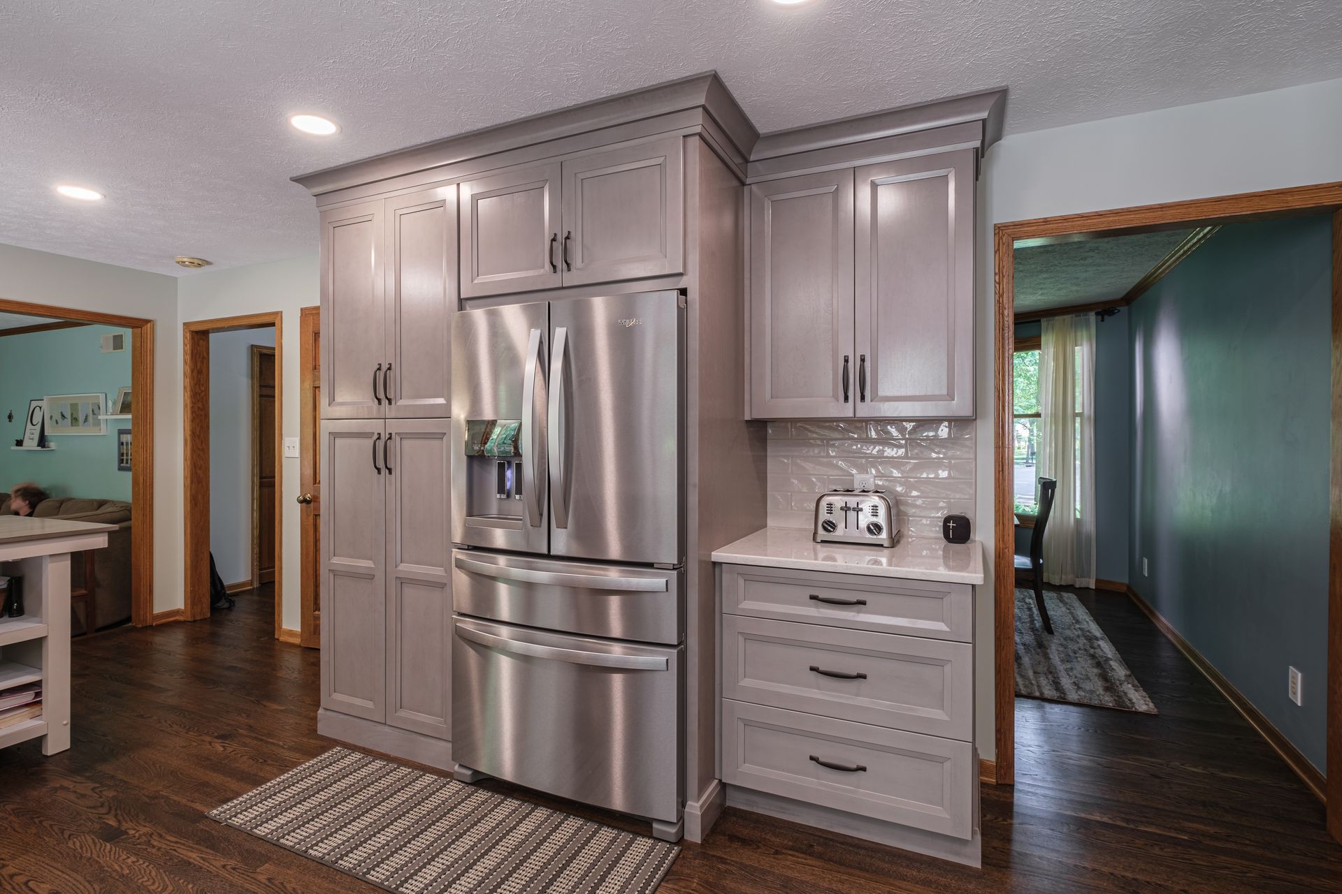 A kitchen with stainless steel appliances and gray cabinets.