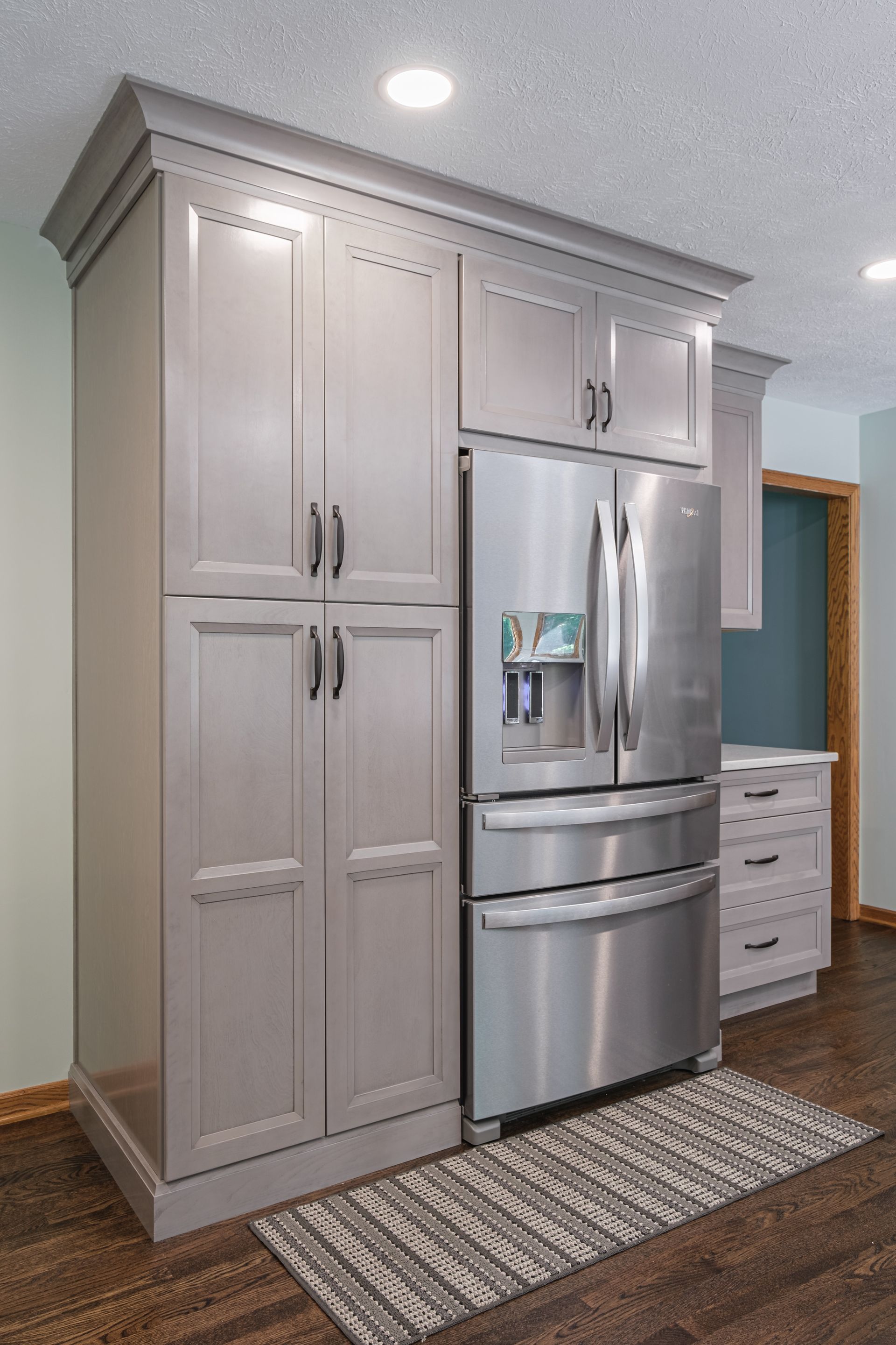 A kitchen with stainless steel appliances and gray cabinets.