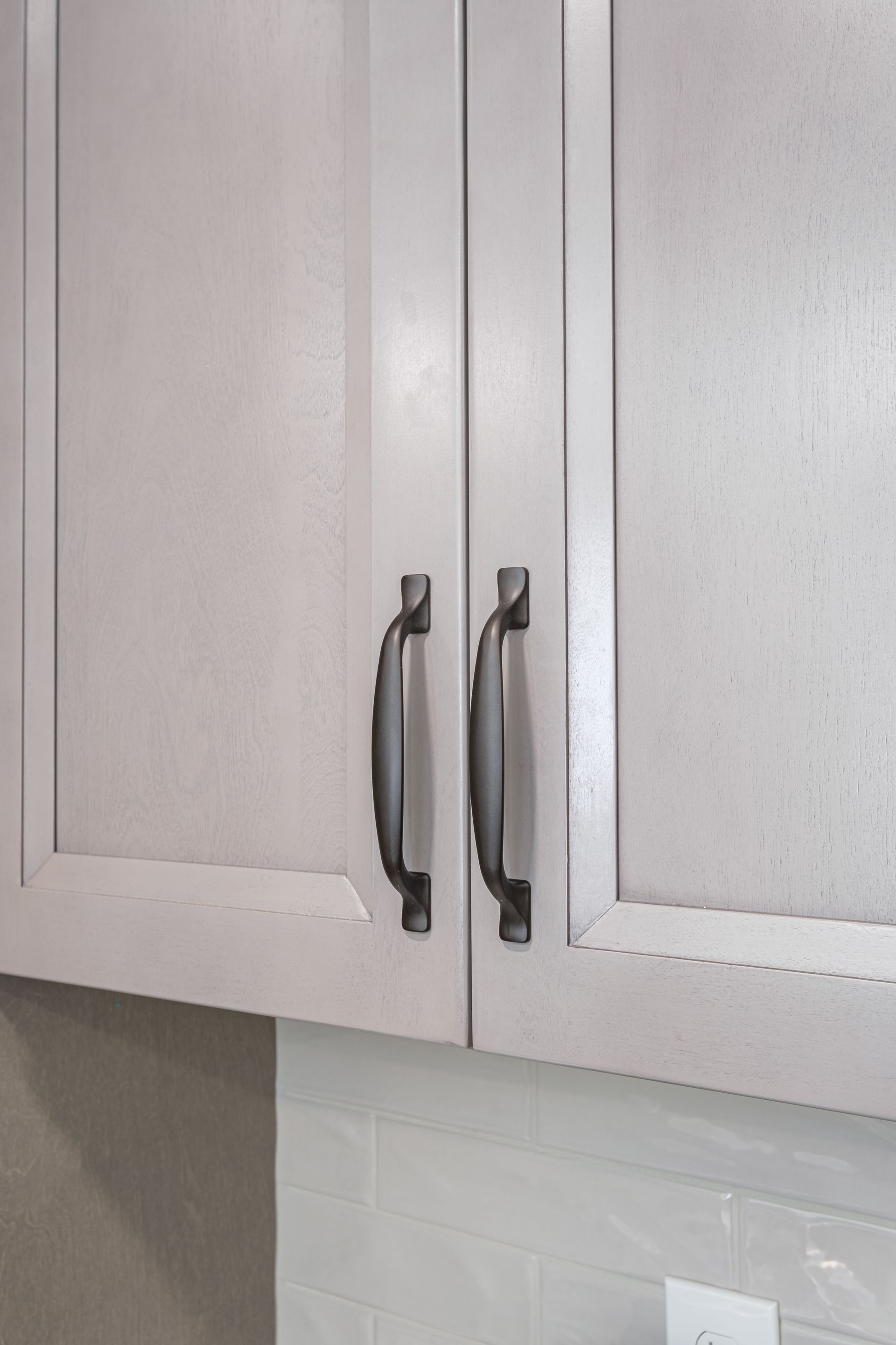A close up of a kitchen cabinet with stainless steel handles.