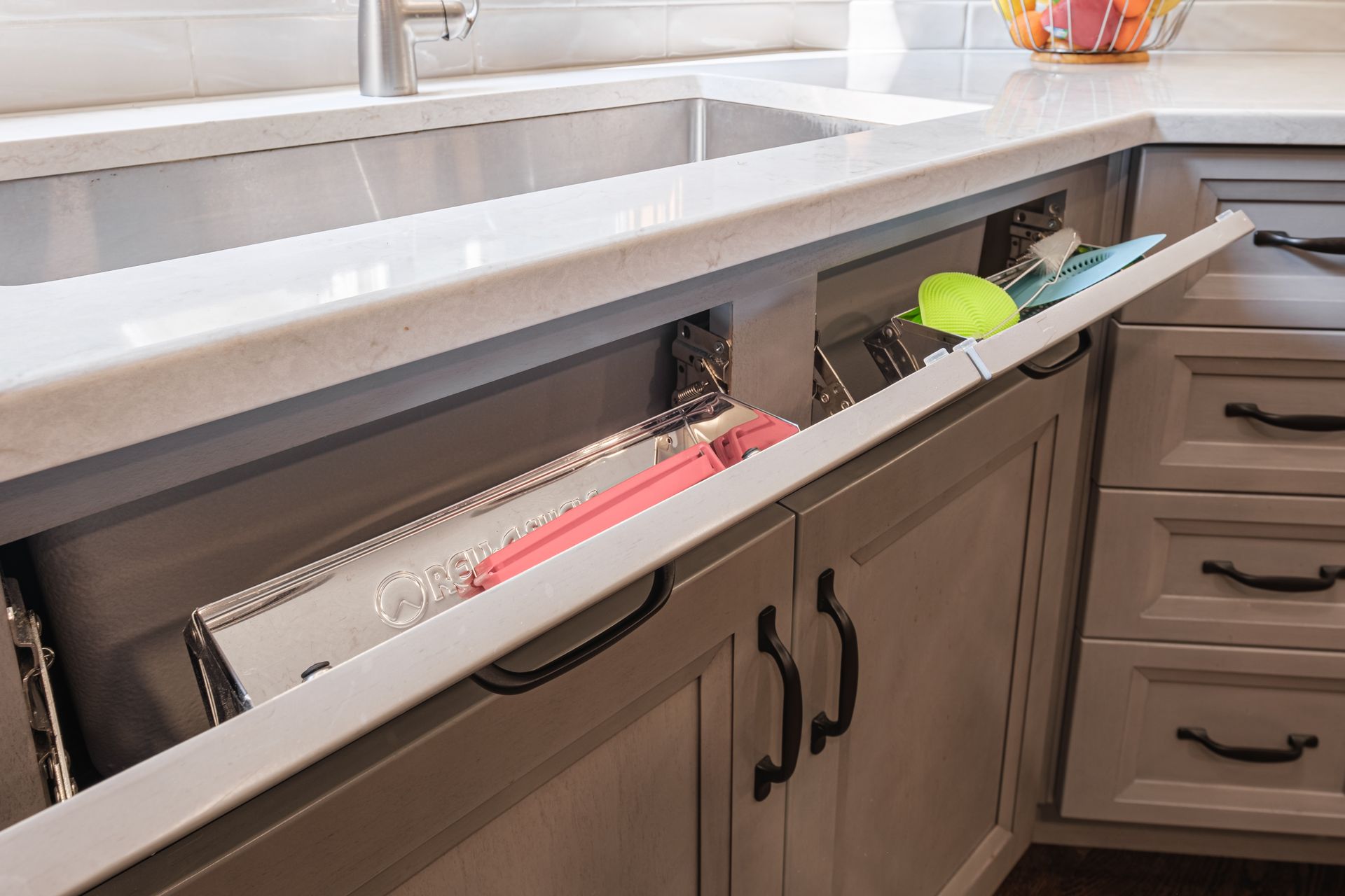 A kitchen sink with a drawer underneath it.