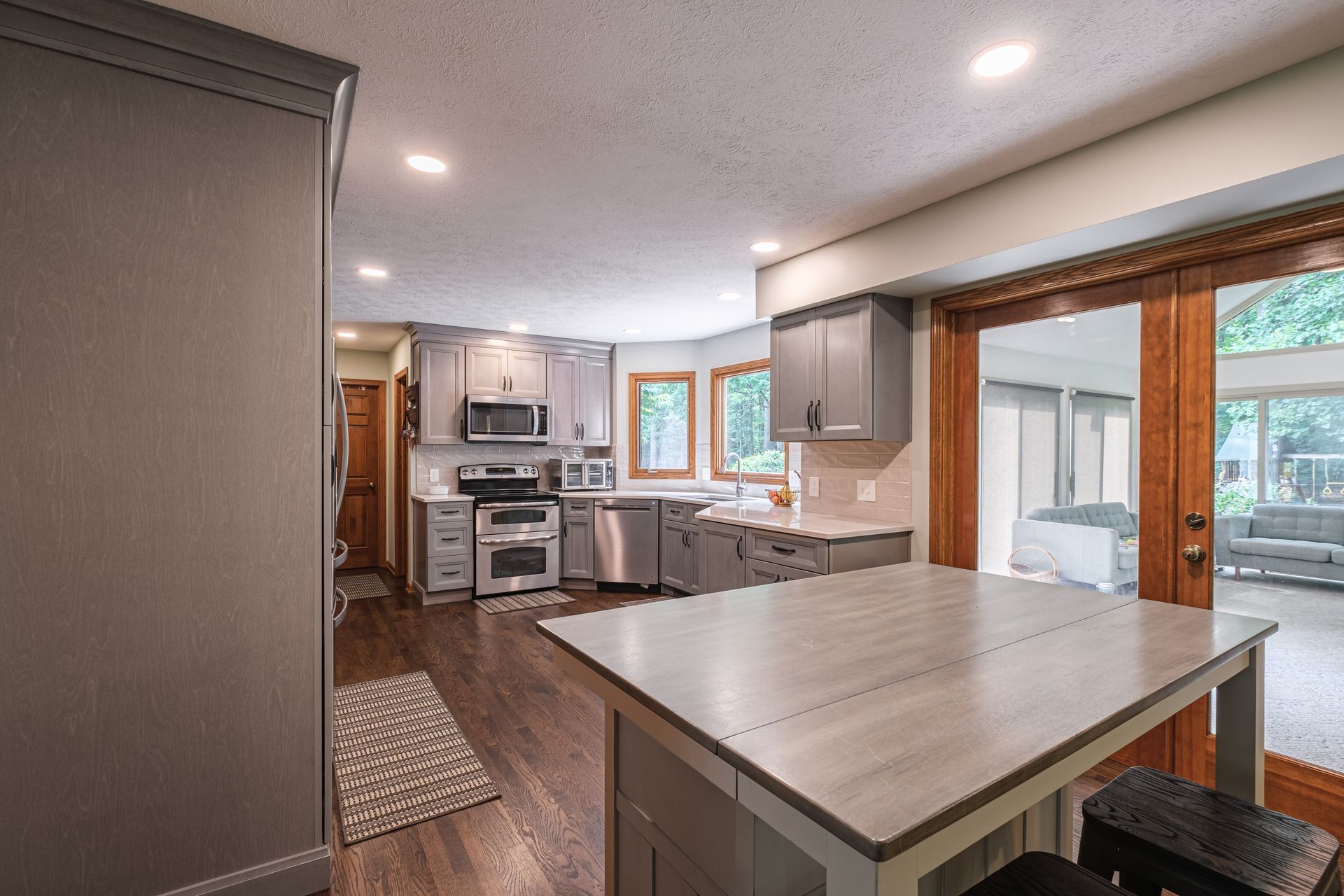 A kitchen with stainless steel appliances and a table in the middle of it.