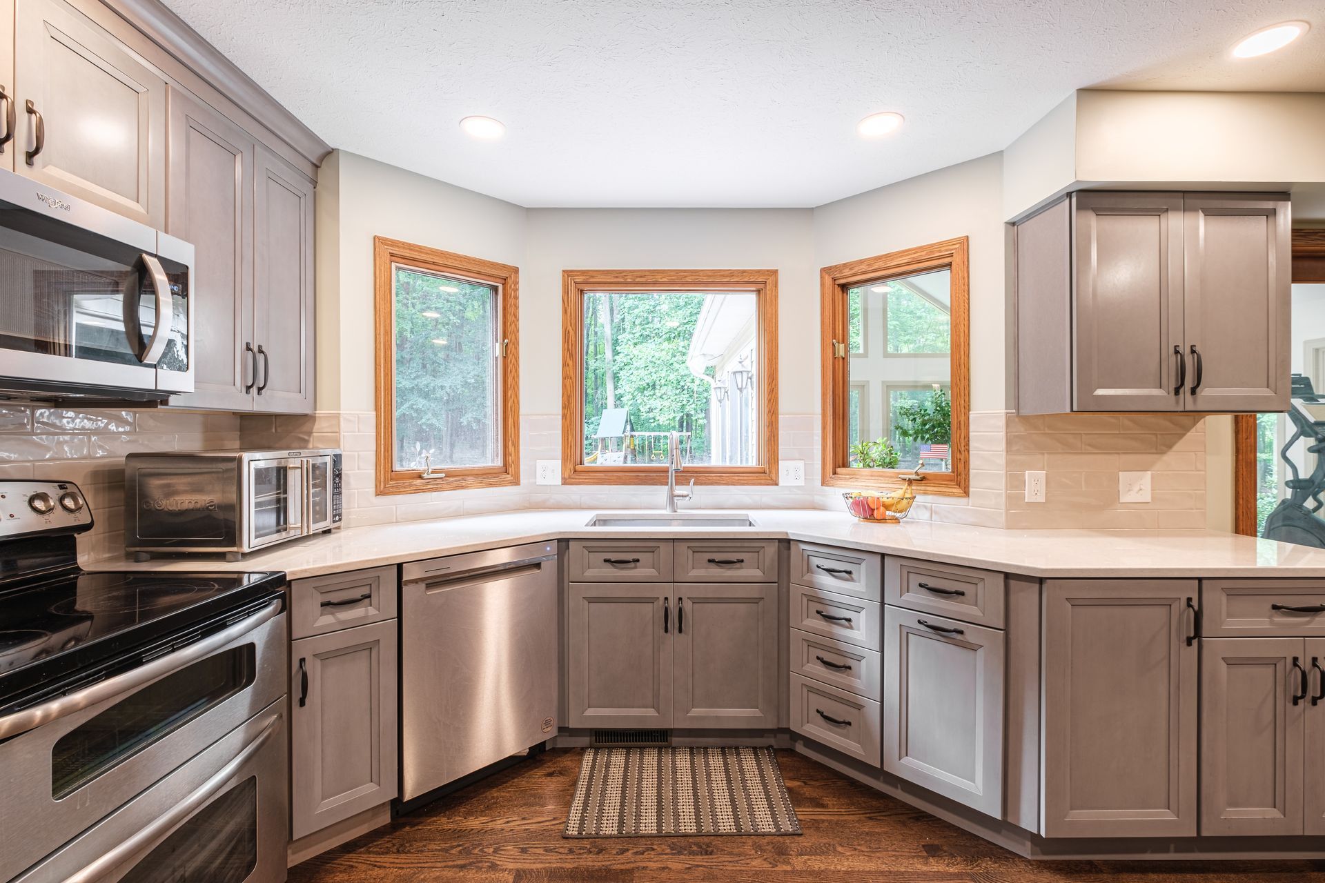 A kitchen with gray cabinets and stainless steel appliances.