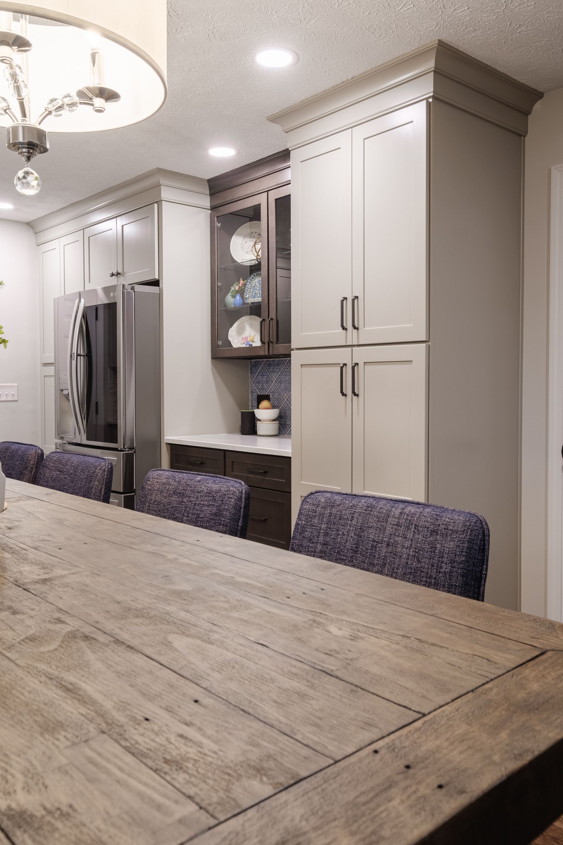 A kitchen with a long wooden table and purple chairs