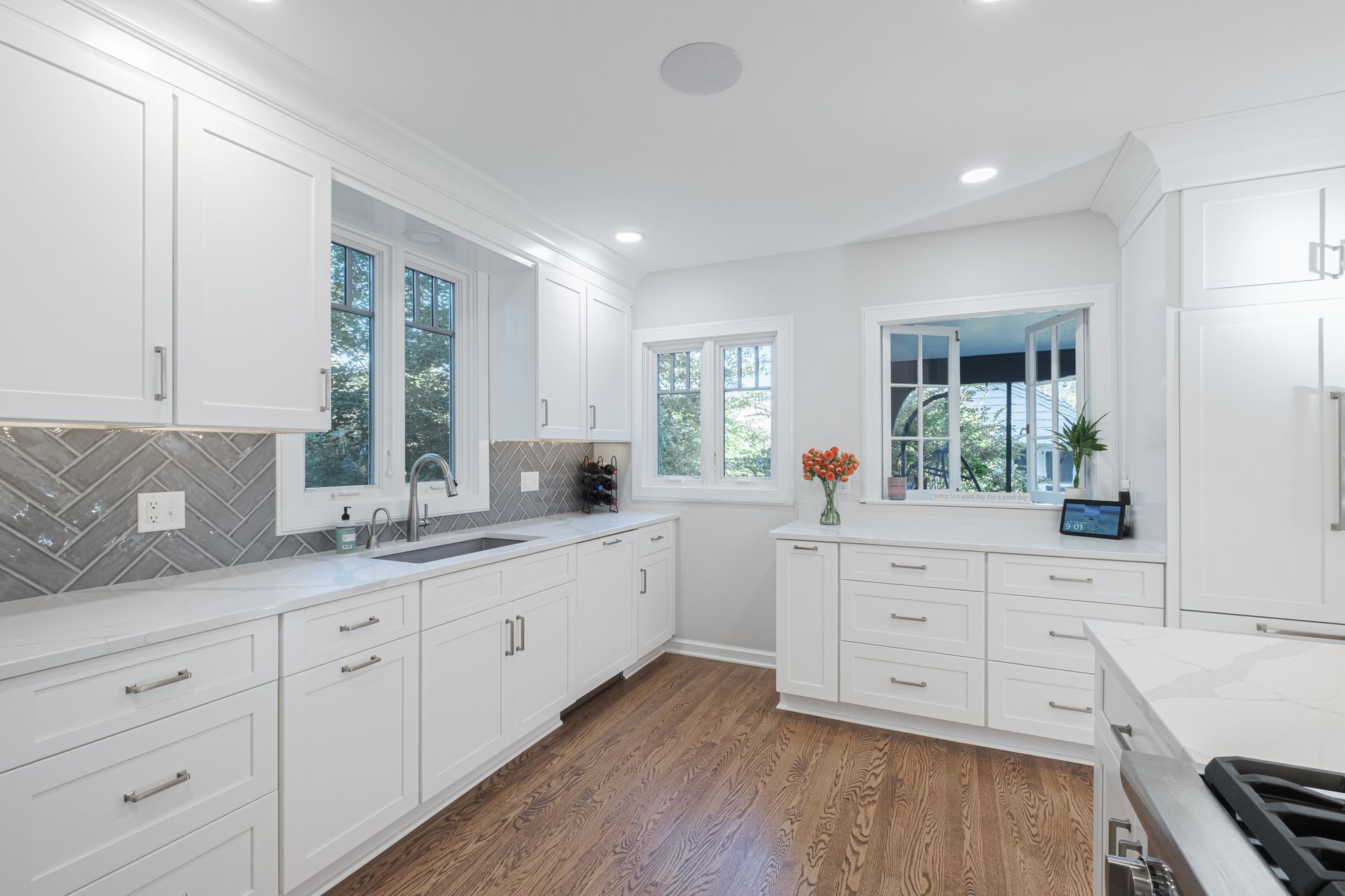 A kitchen with white cabinets , stainless steel appliances , and hardwood floors.