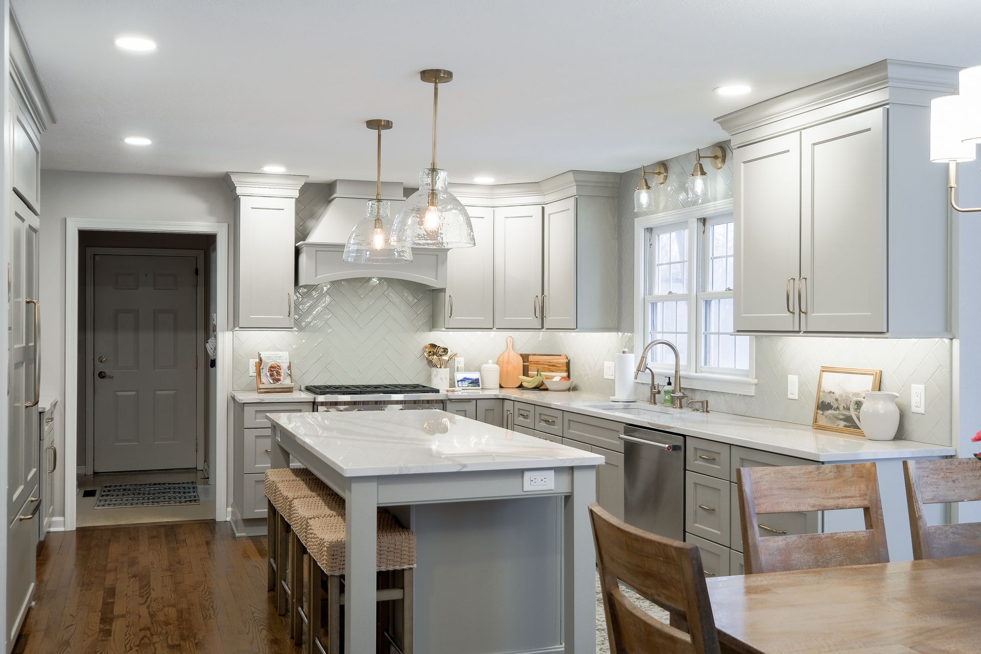 Spacious, modern kitchen with gray cabinets, island, and wood floors.
