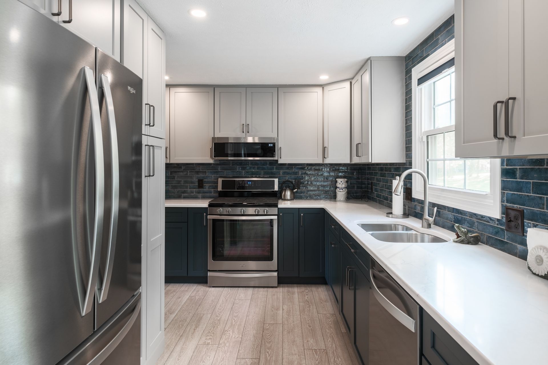 A kitchen with stainless steel appliances and white cabinets.