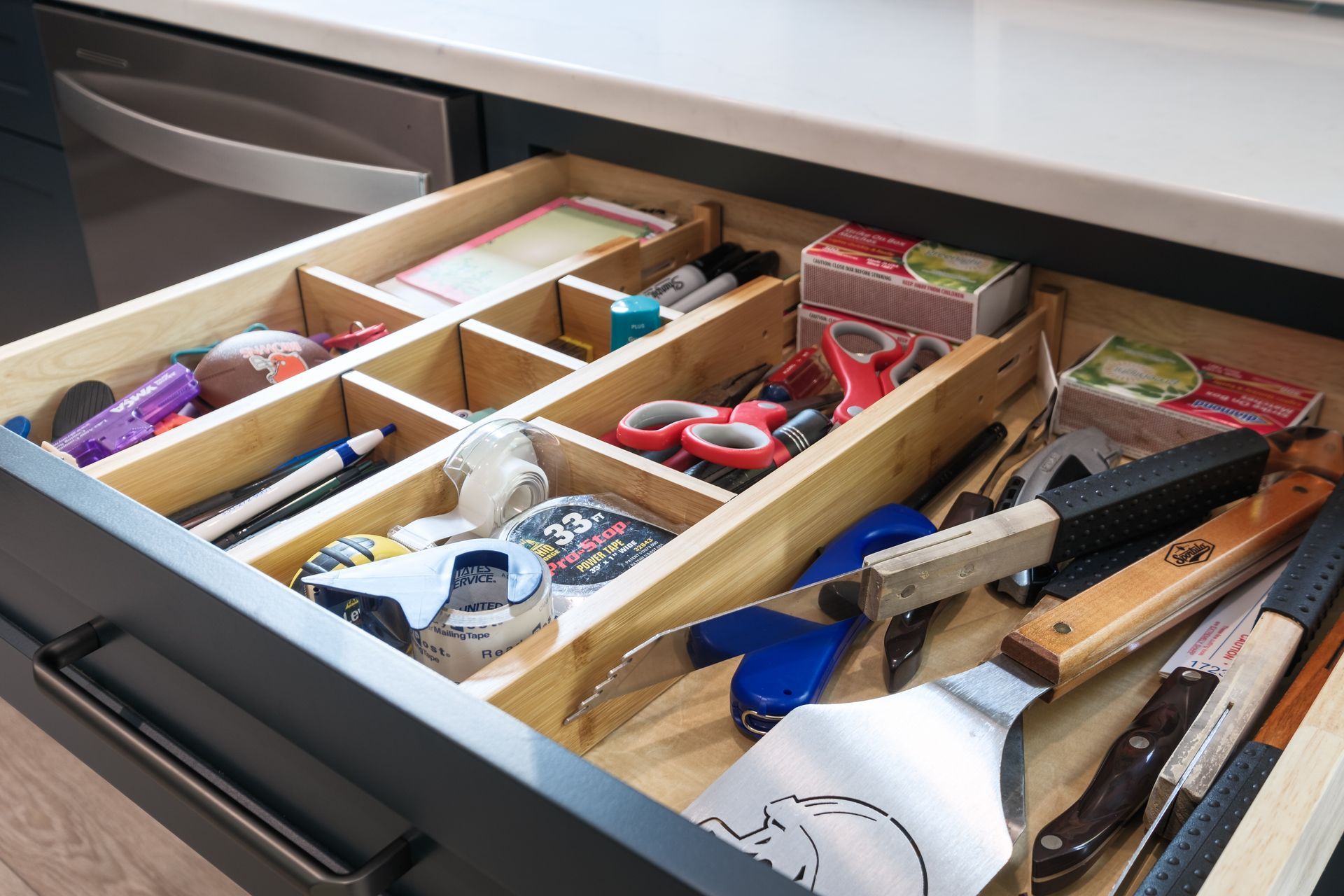 A kitchen drawer filled with a variety of utensils.