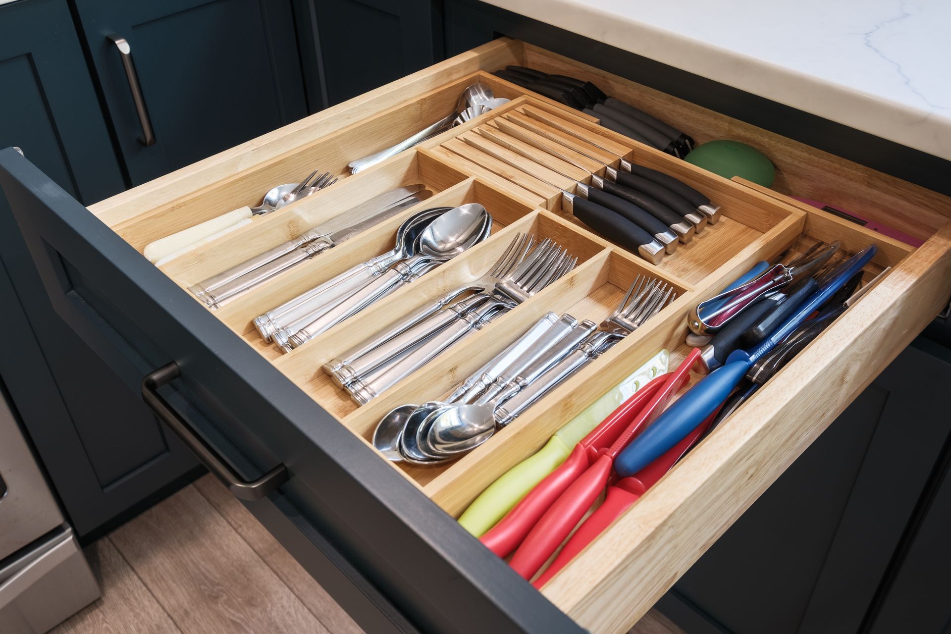 A kitchen drawer filled with silverware and knives.