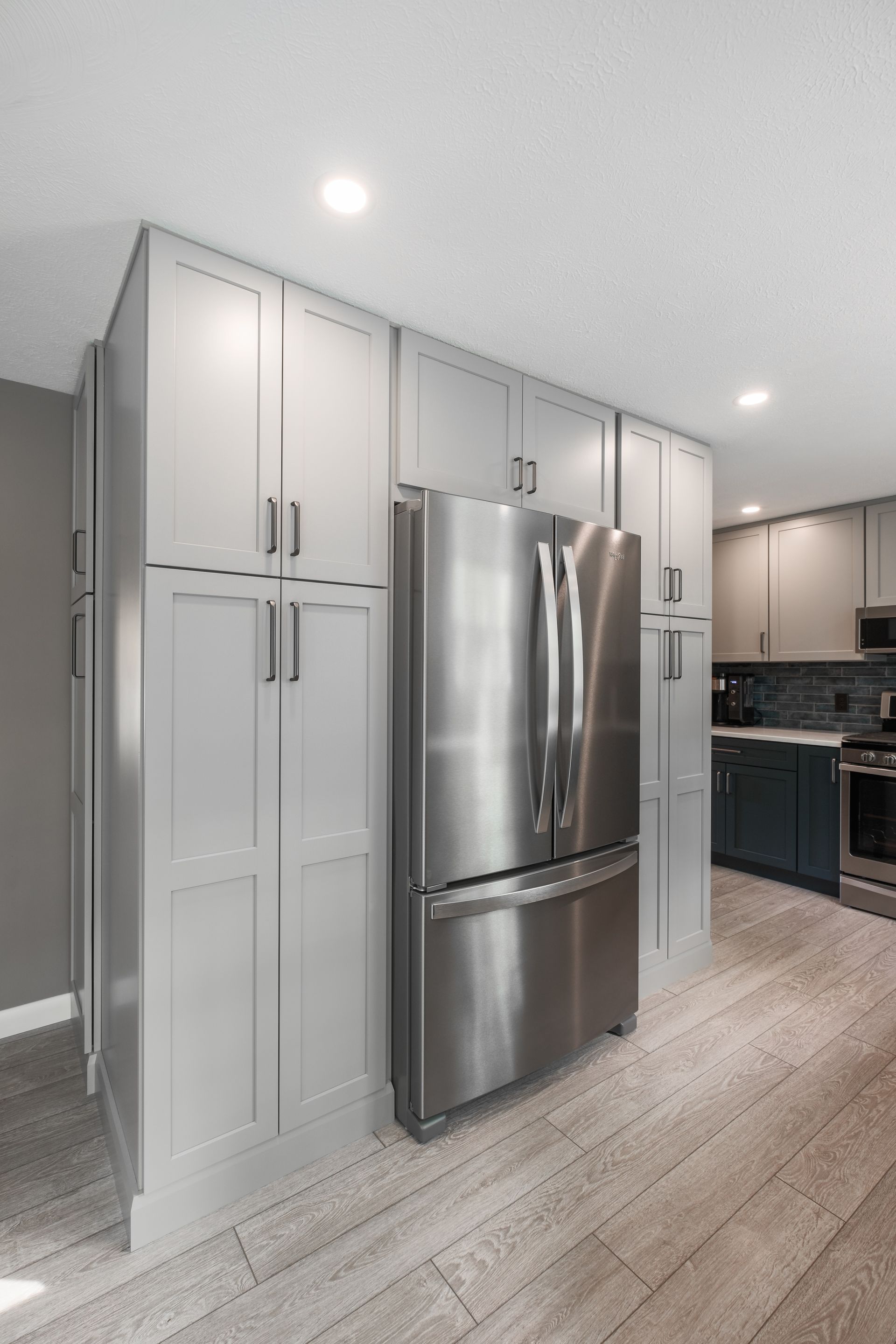 A kitchen with stainless steel appliances and white cabinets.