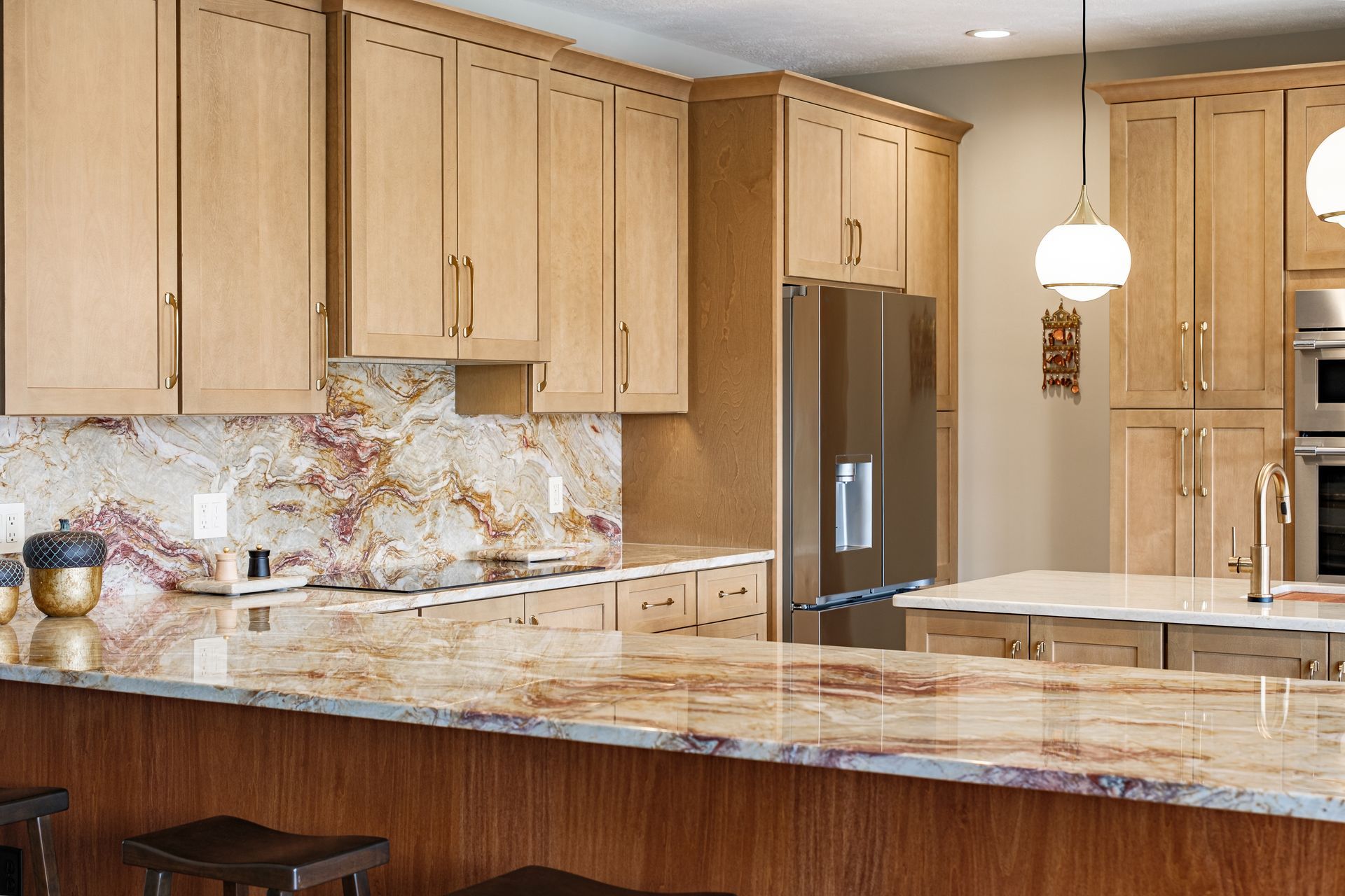 Kitchen with light wood cabinets, granite countertops, and stainless steel appliances.