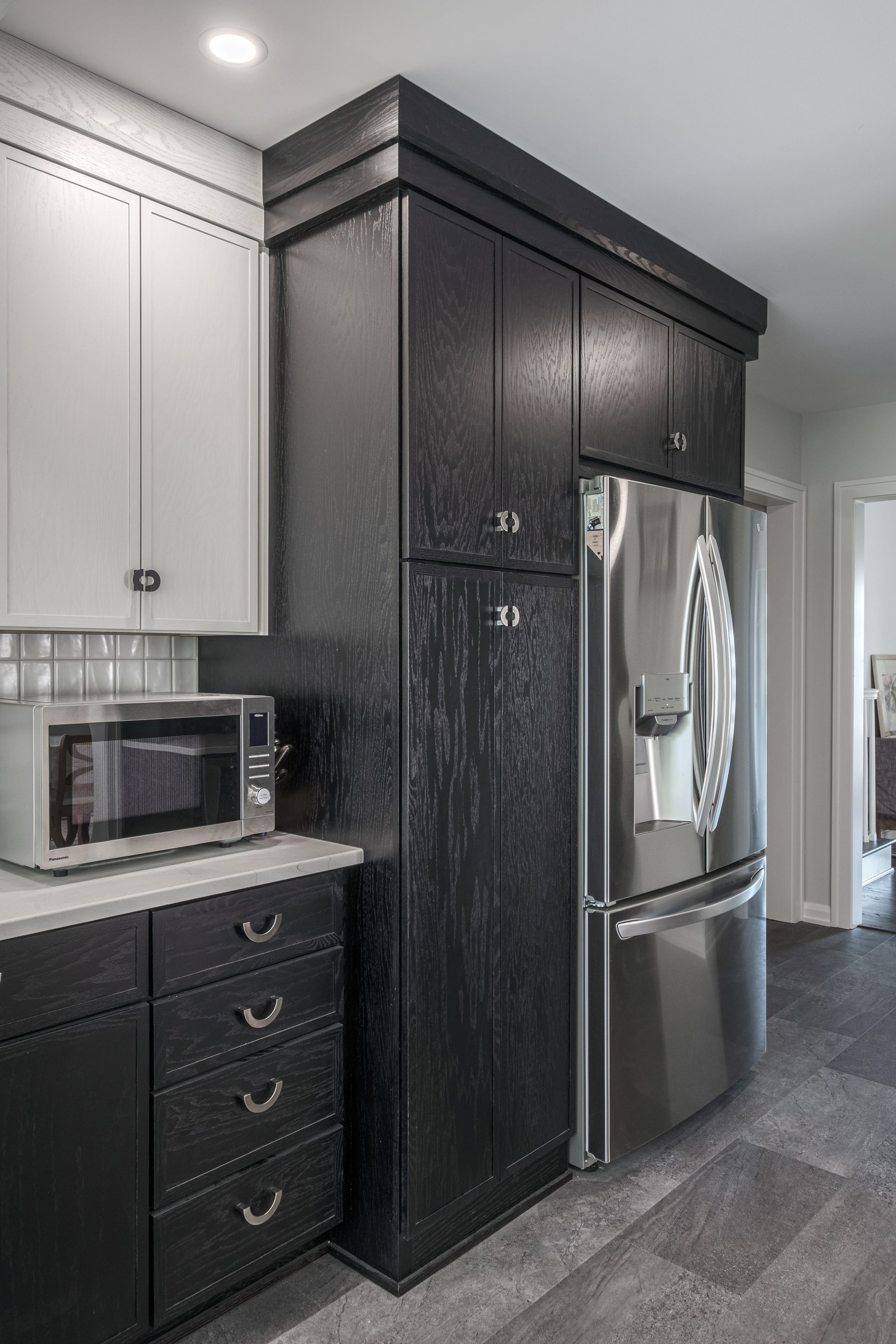 Black and white kitchen with a refrigerator and microwave.