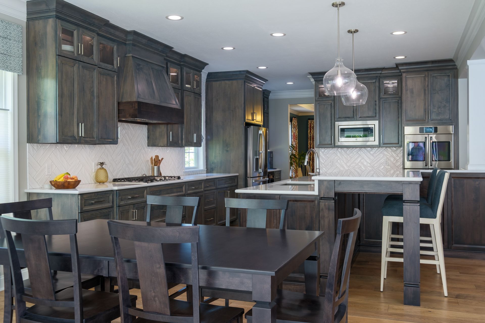 Dark wood kitchen with dining table and island seating.
