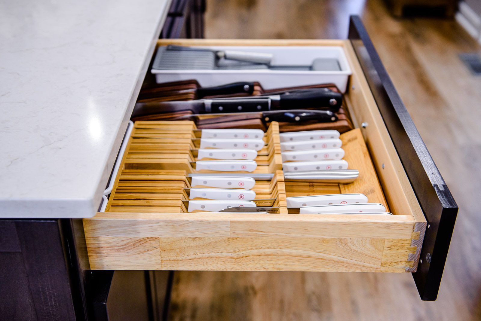 A kitchen drawer filled with knives and utensils.