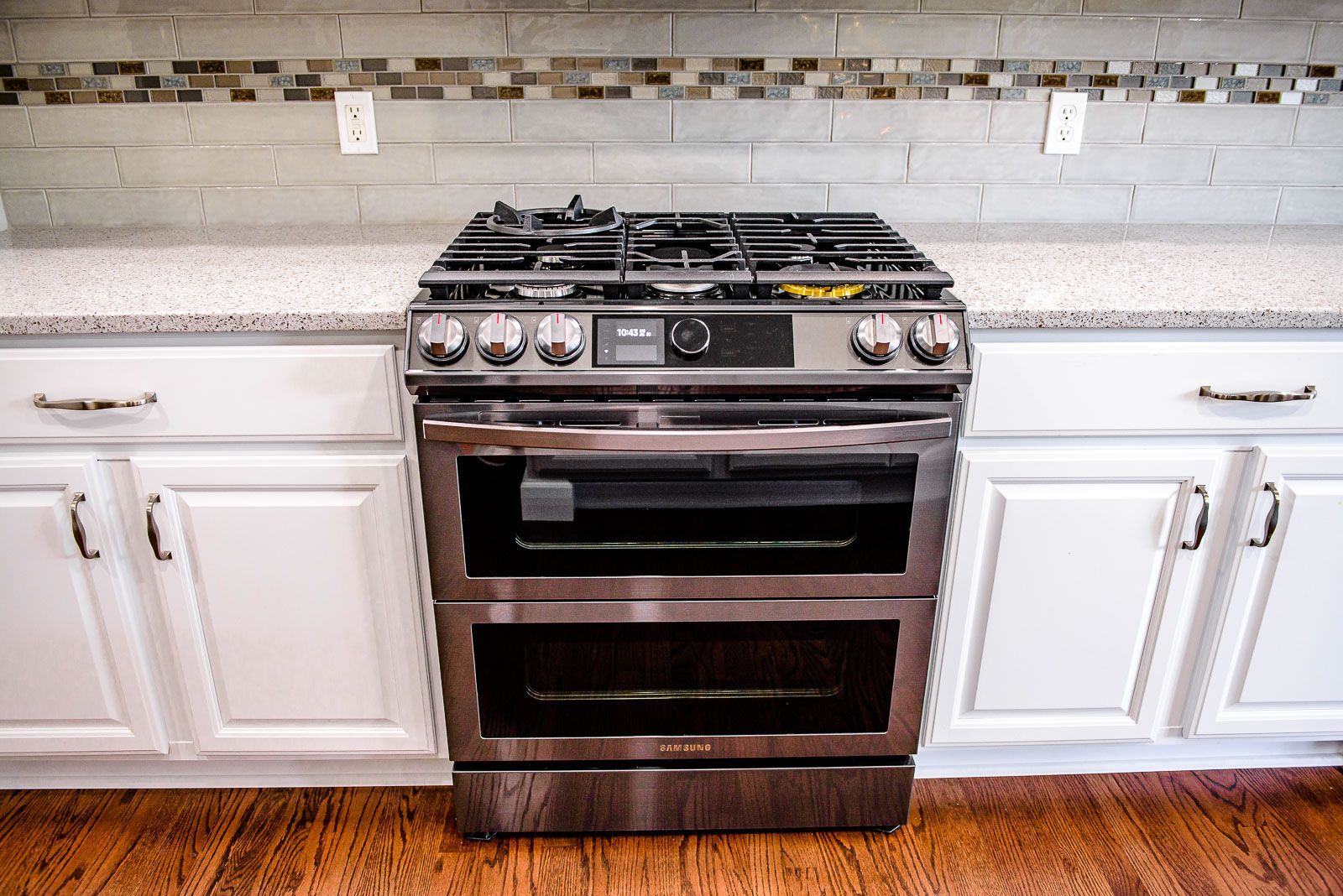 Stainless steel double oven range in a white kitchen.