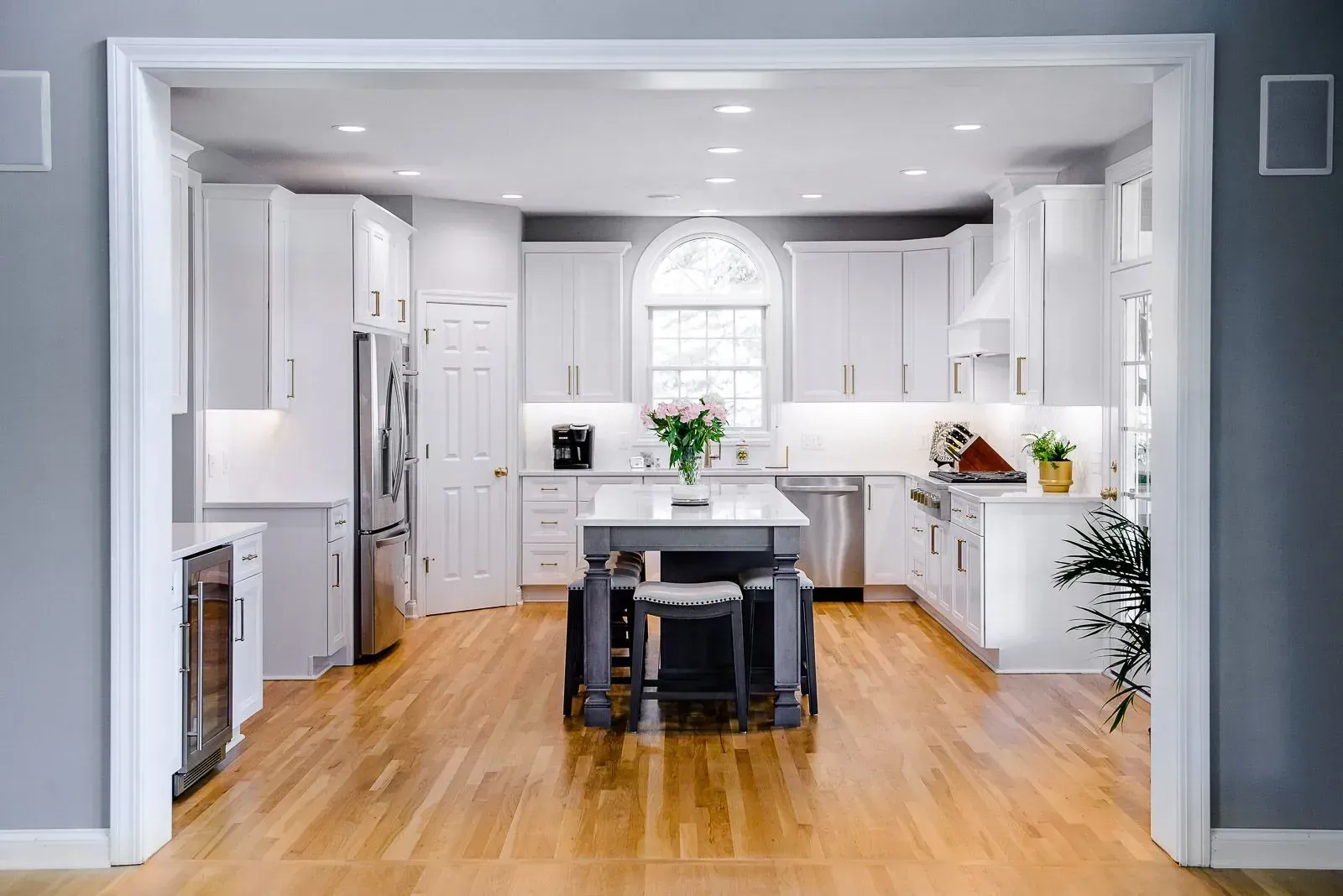 A kitchen with white cabinets and a large island in the middle.