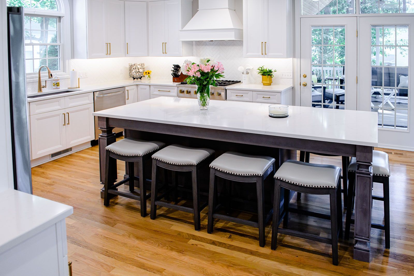 There is a large island in the middle of the kitchen with stools around it.