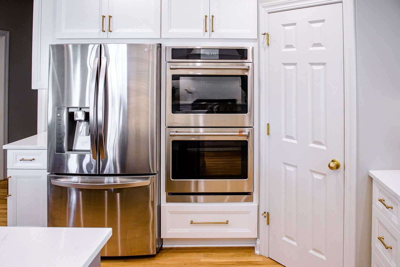 A kitchen with stainless steel appliances and white cabinets.