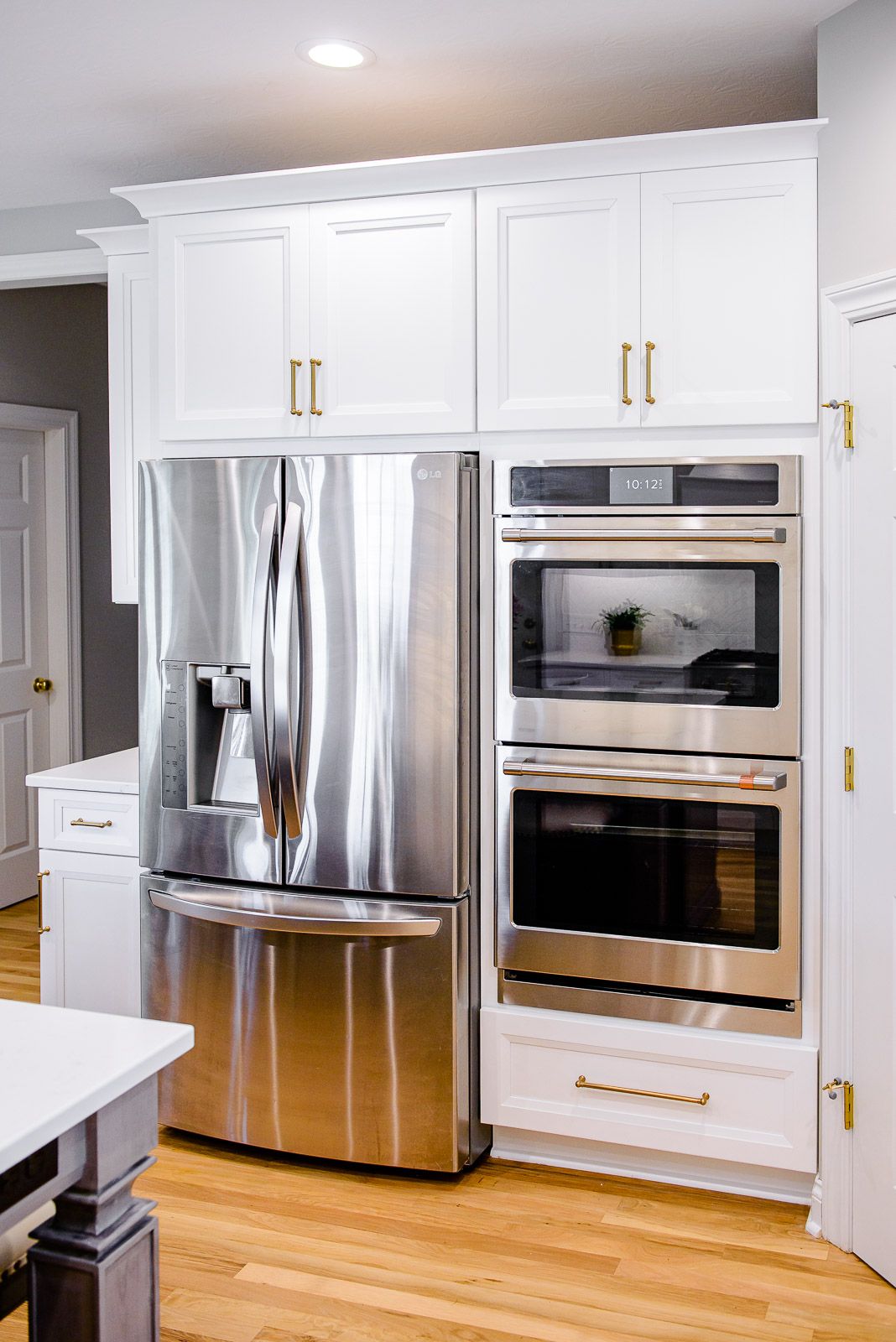A kitchen with stainless steel appliances and white cabinets.