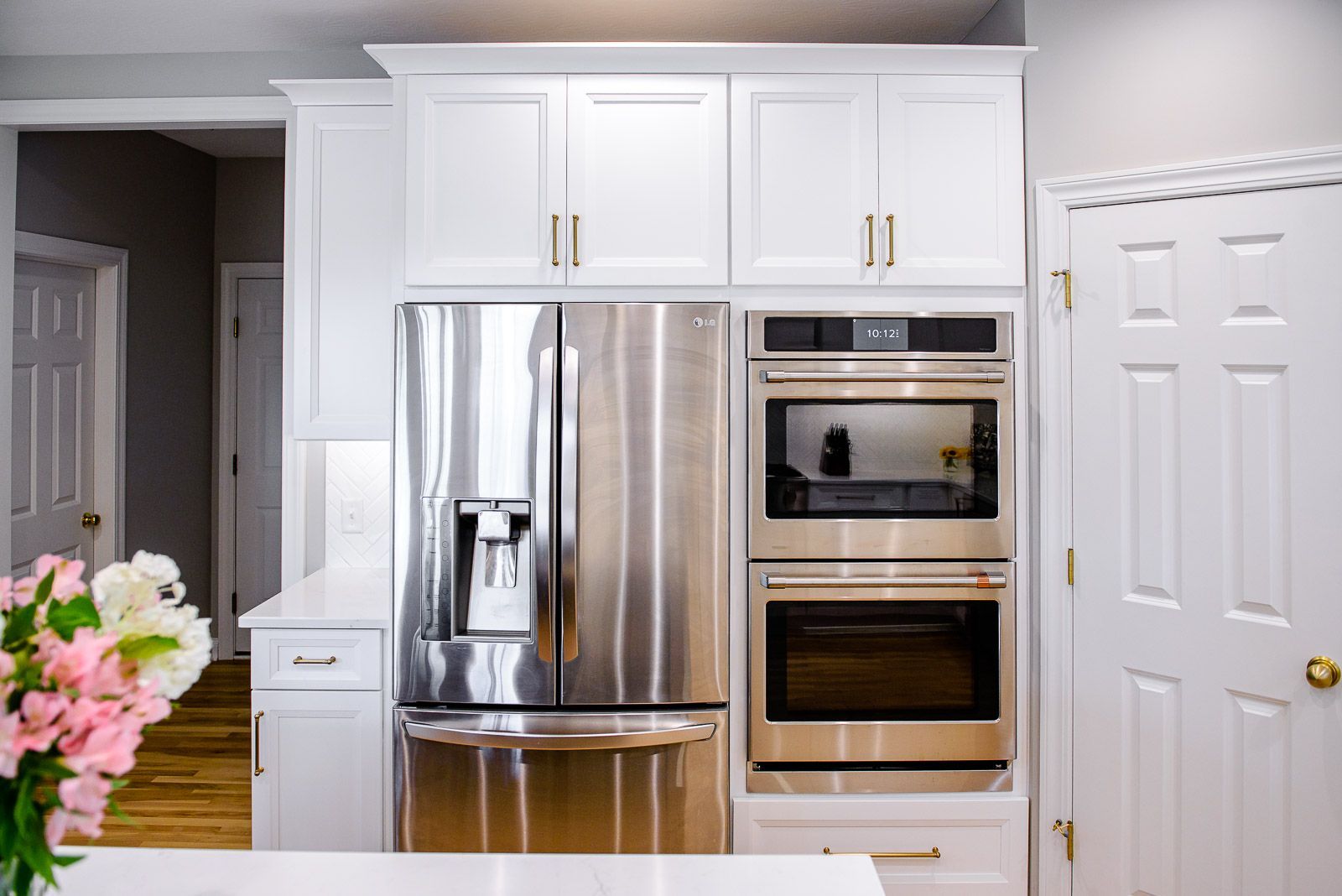 A kitchen with stainless steel appliances and white cabinets.