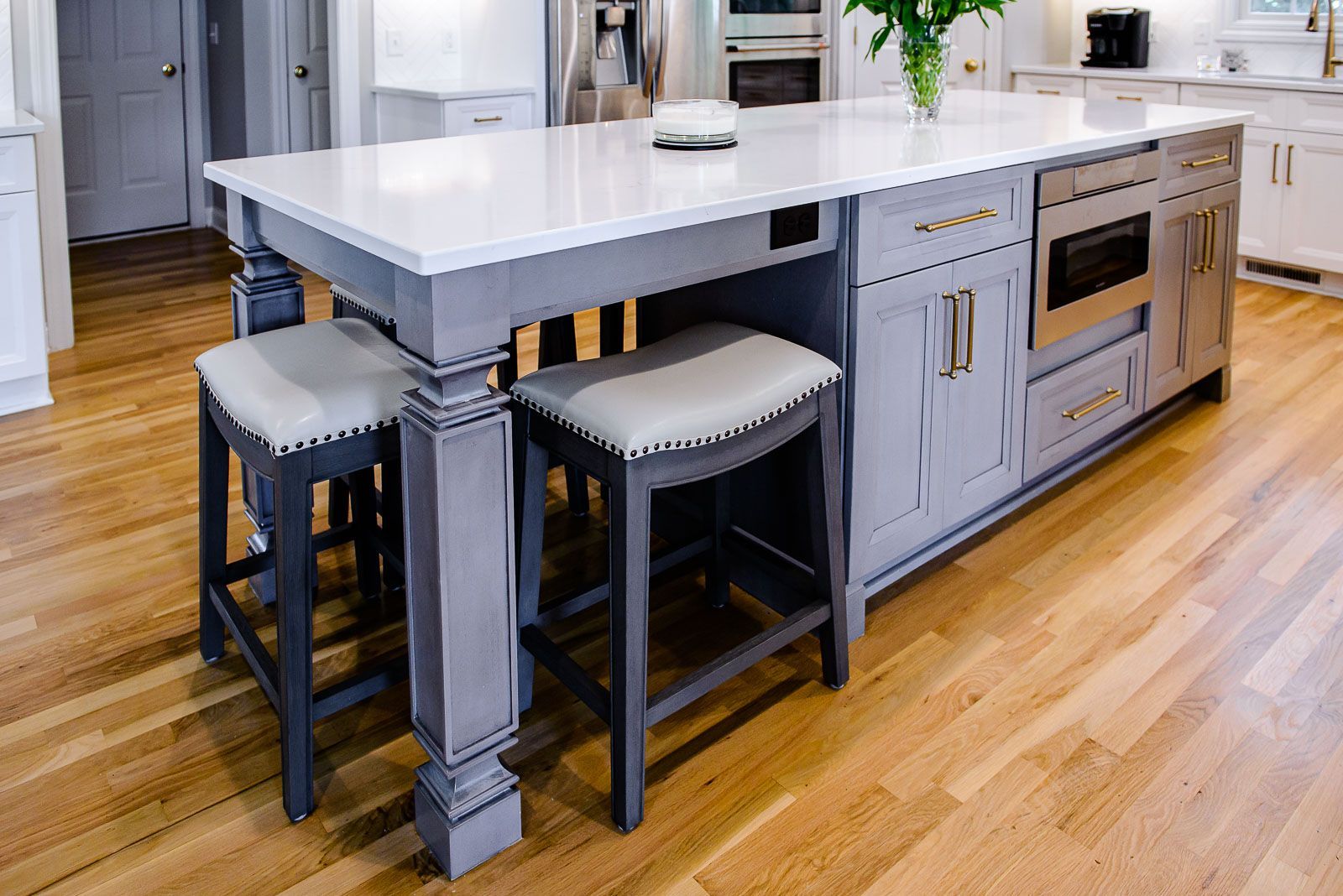 A kitchen with a large island and stools.