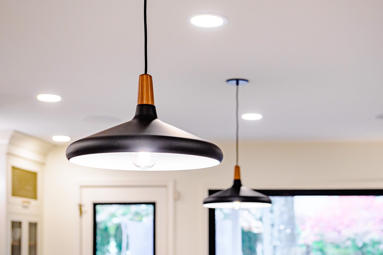 Two pendant lights are hanging from the ceiling in a kitchen.