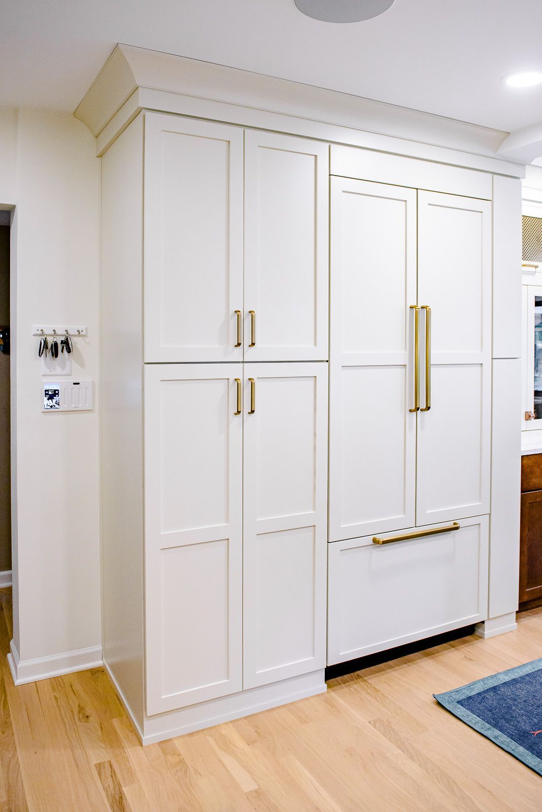 A kitchen with white cabinets and a refrigerator freezer.