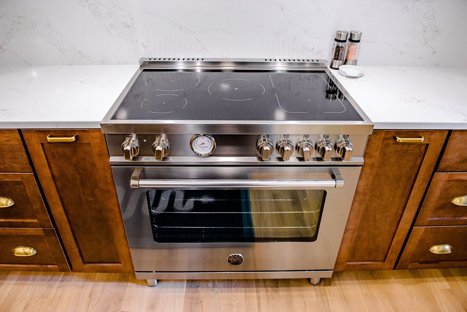 A stainless steel stove and oven in a kitchen with wooden cabinets.