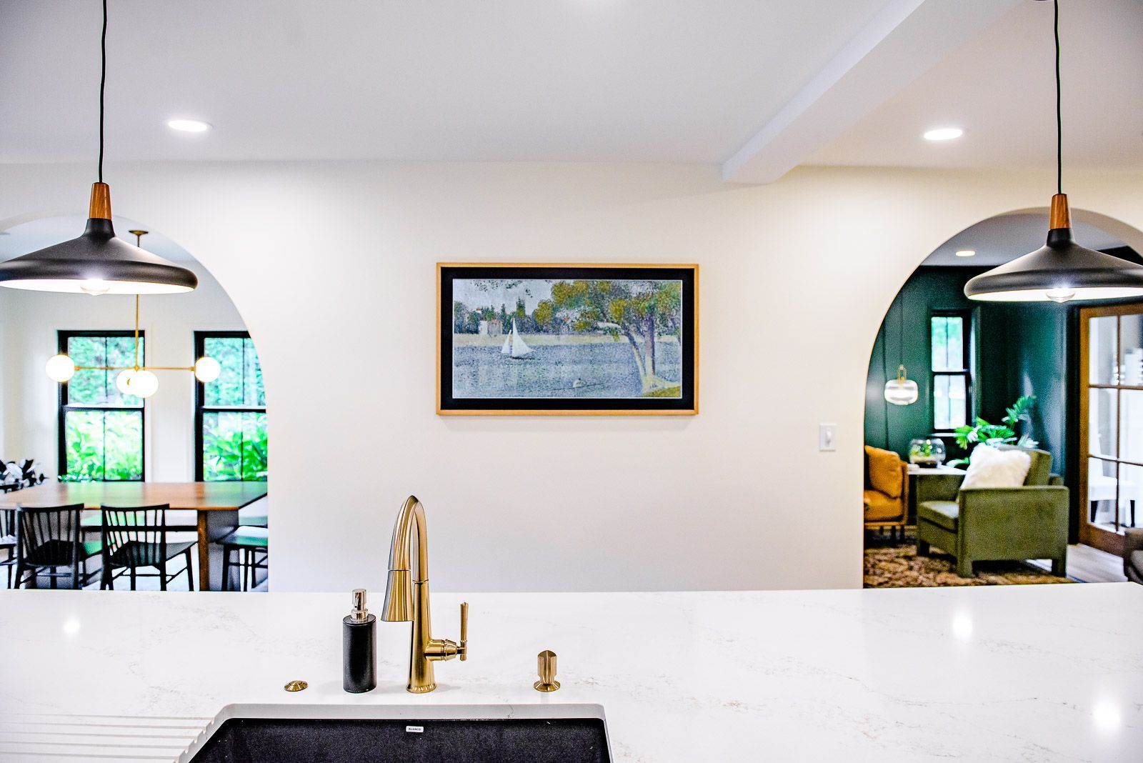 A kitchen with a sink and a painting on the wall.