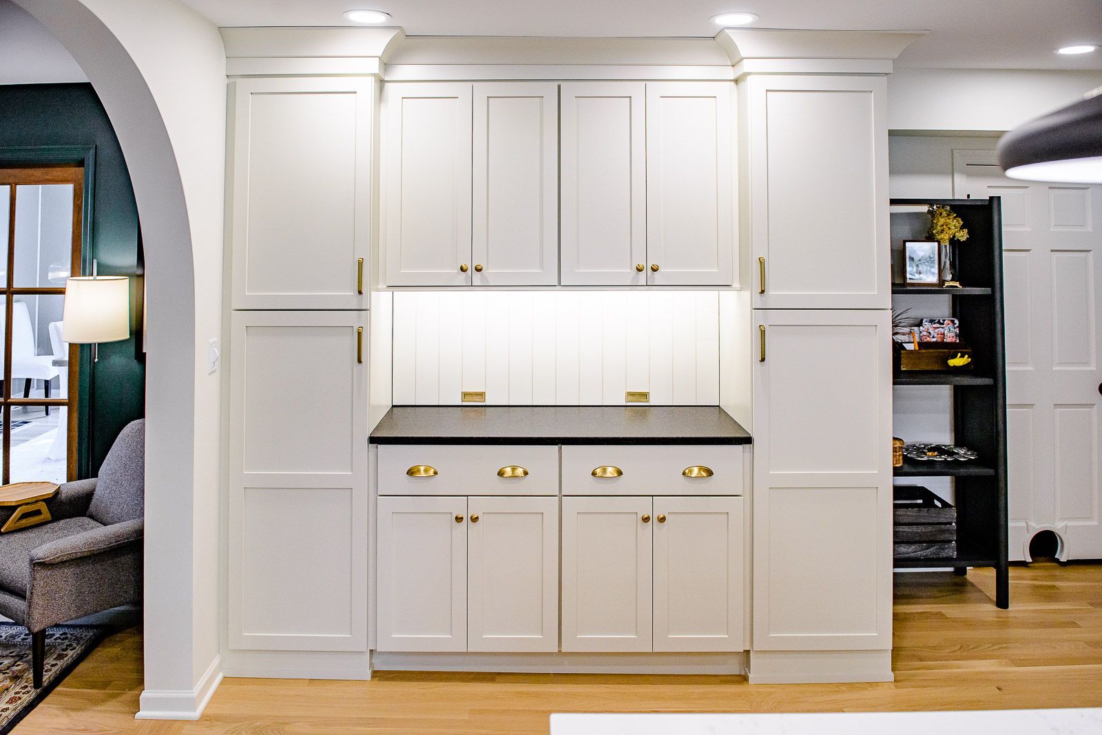A kitchen with white cabinets and a black counter top.
