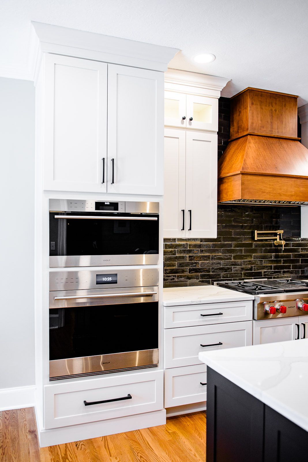 A kitchen with white cabinets and stainless steel appliances