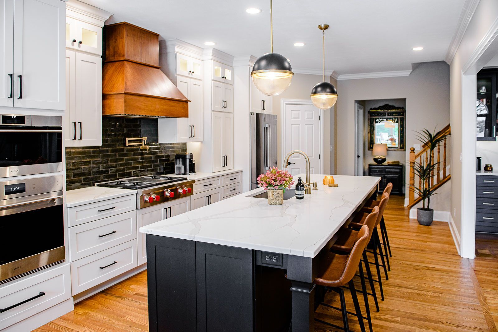 A kitchen with white cabinets , stainless steel appliances , and a large island.