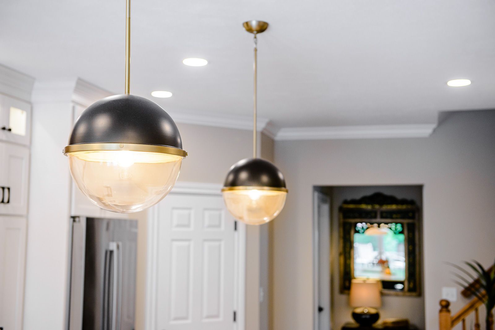 Two pendant lights are hanging from the ceiling in a kitchen.