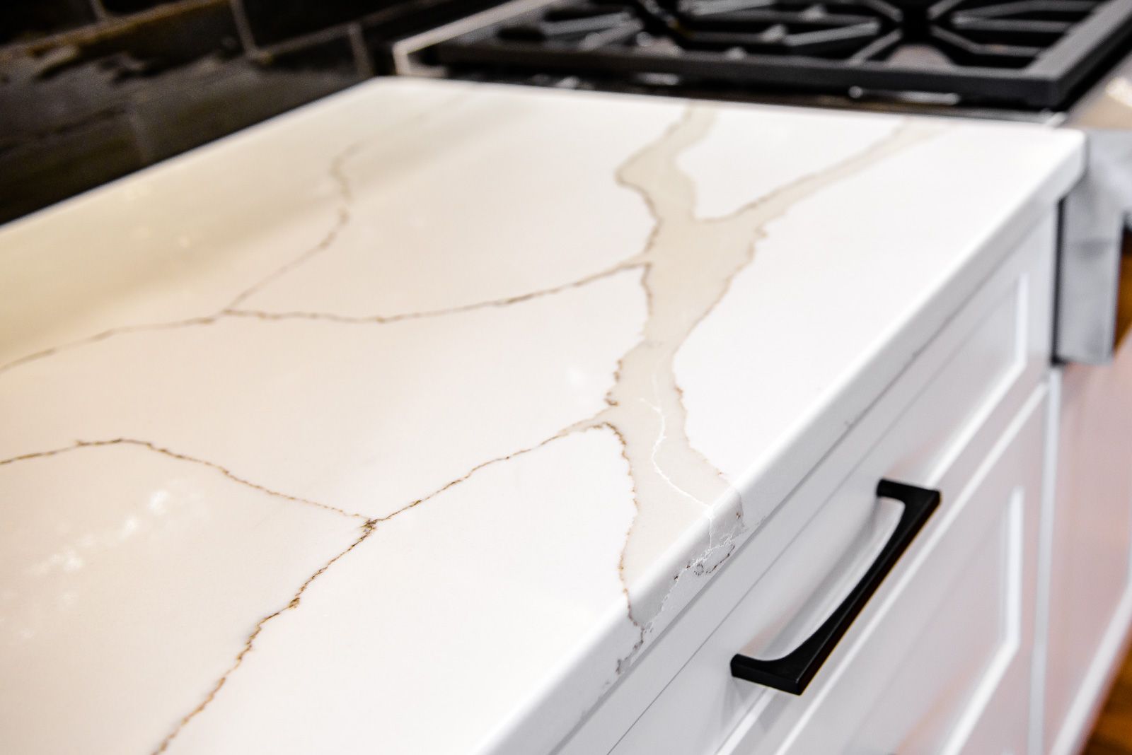 A kitchen counter with a stove top oven and a marble counter top.