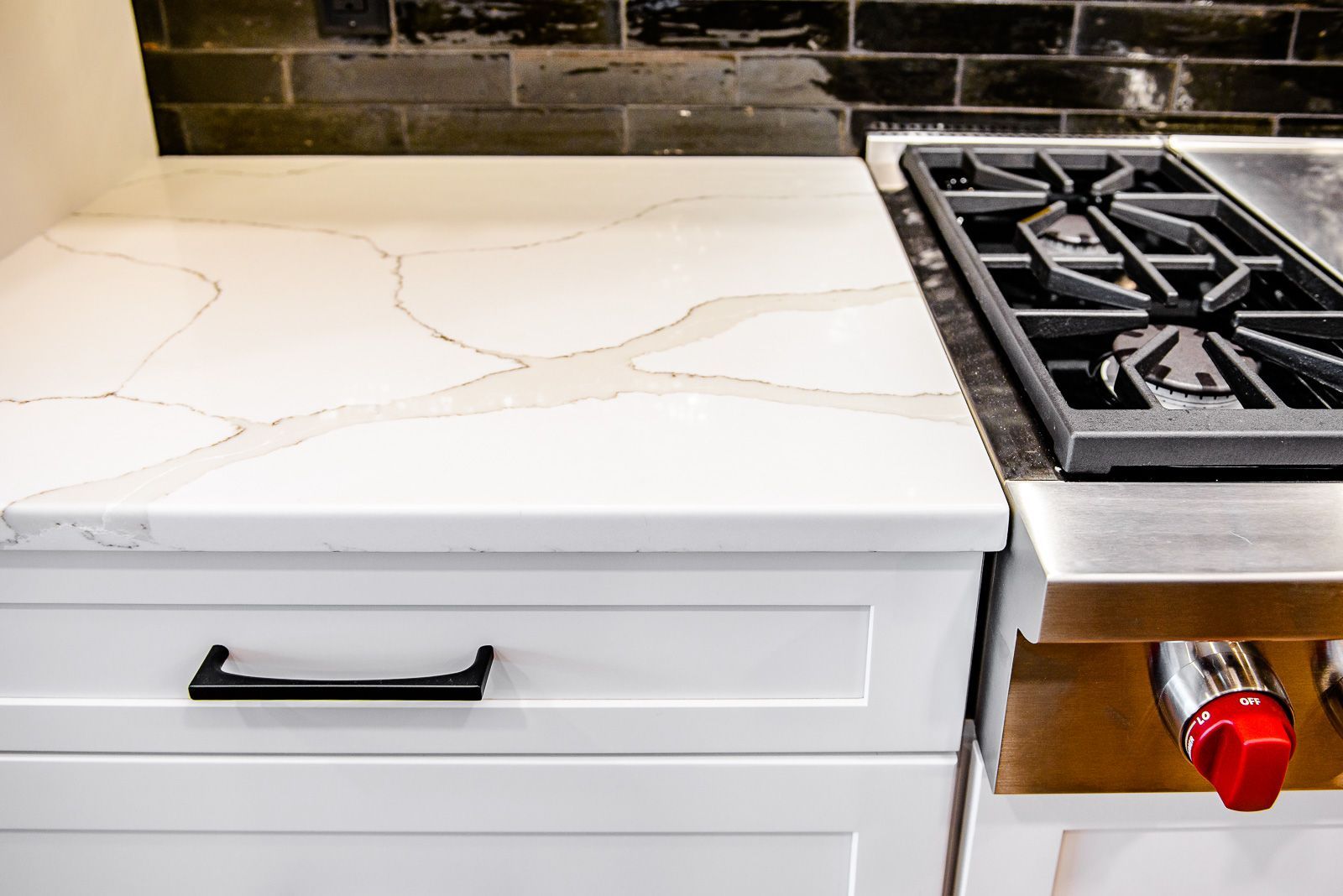 A stove top oven is sitting on top of a white counter in a kitchen.
