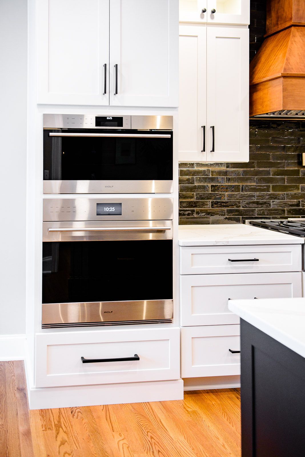 A kitchen with white cabinets and stainless steel appliances