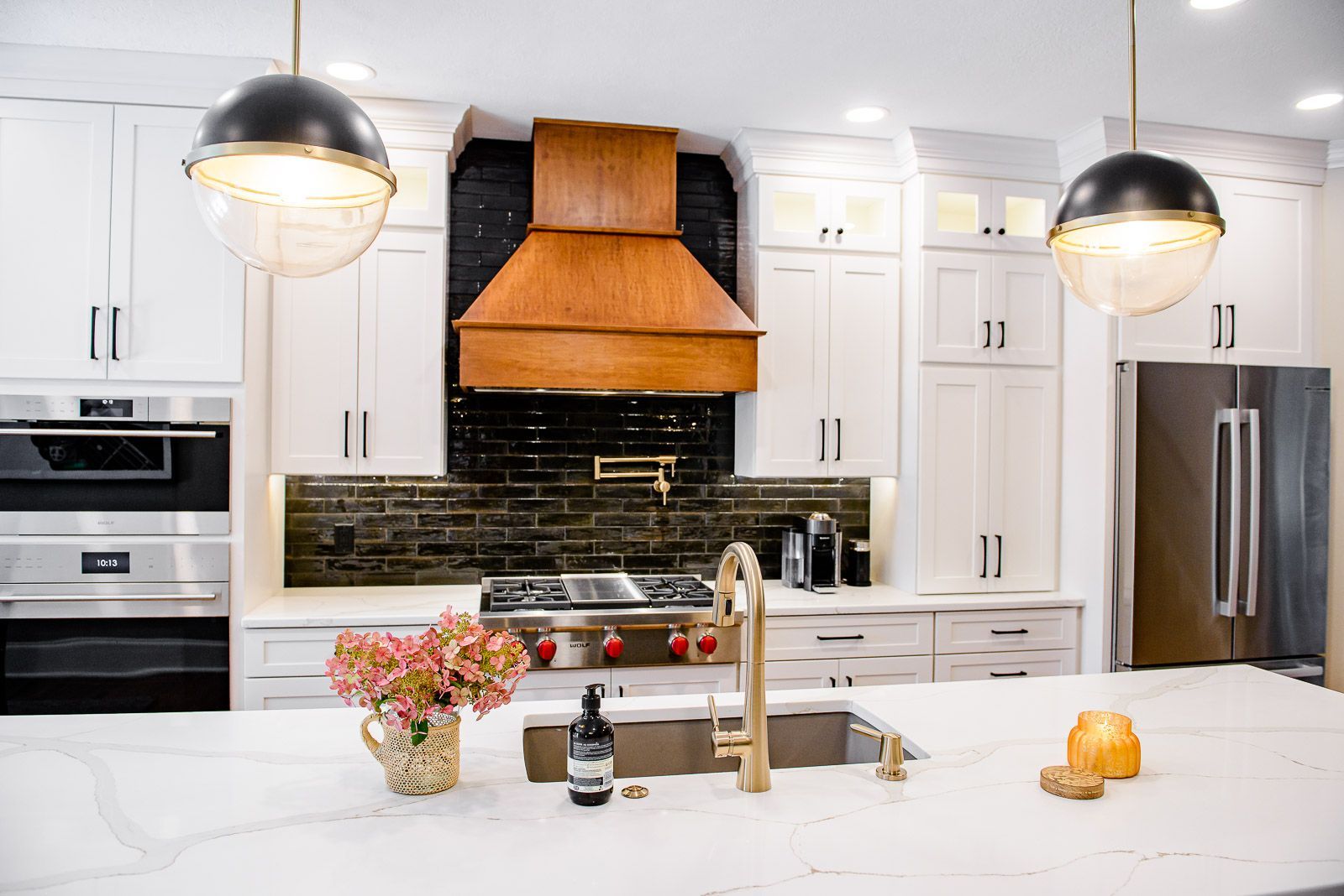 A kitchen with white cabinets , stainless steel appliances , a sink , and a stove.