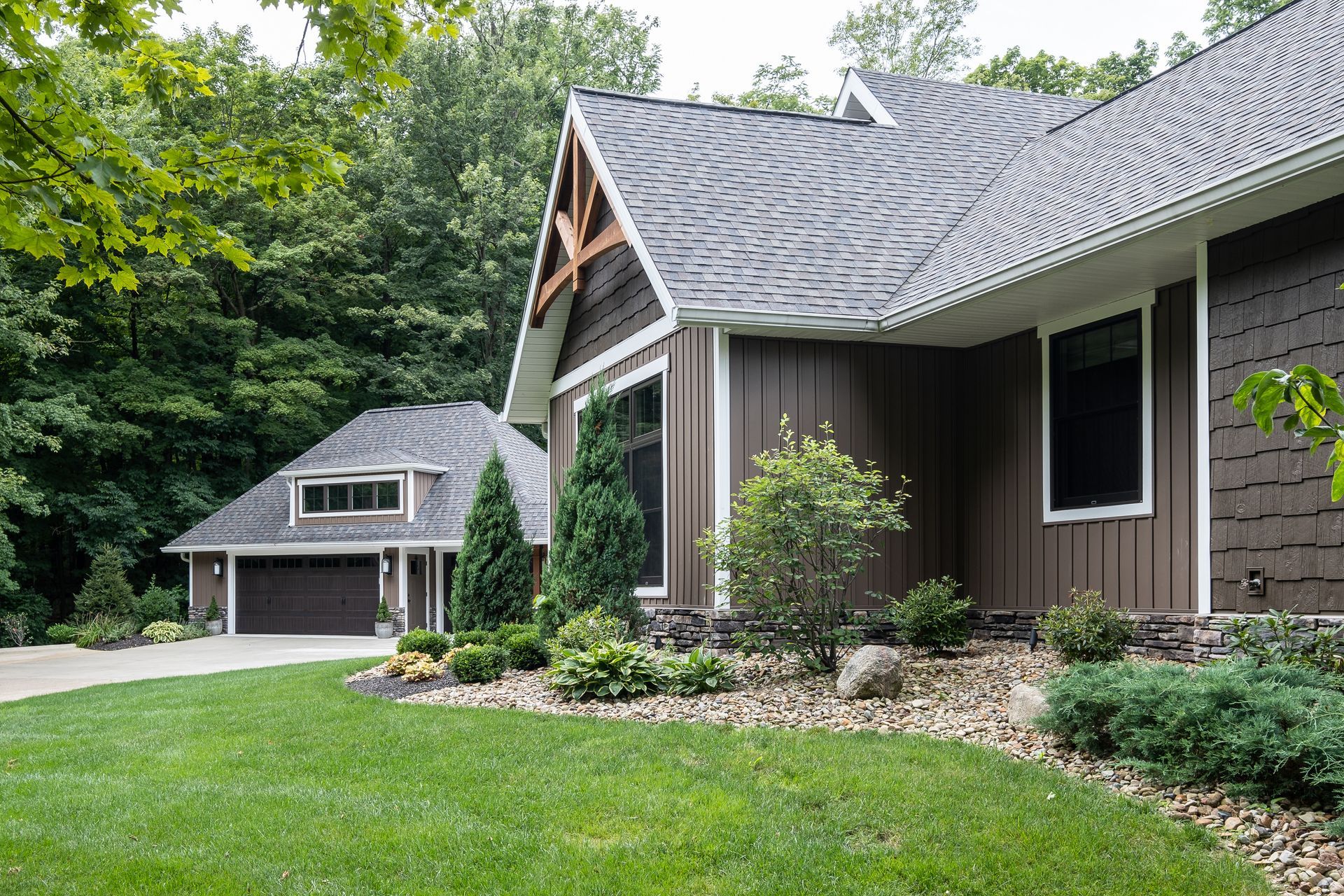 Brown house with a garage and green lawn.