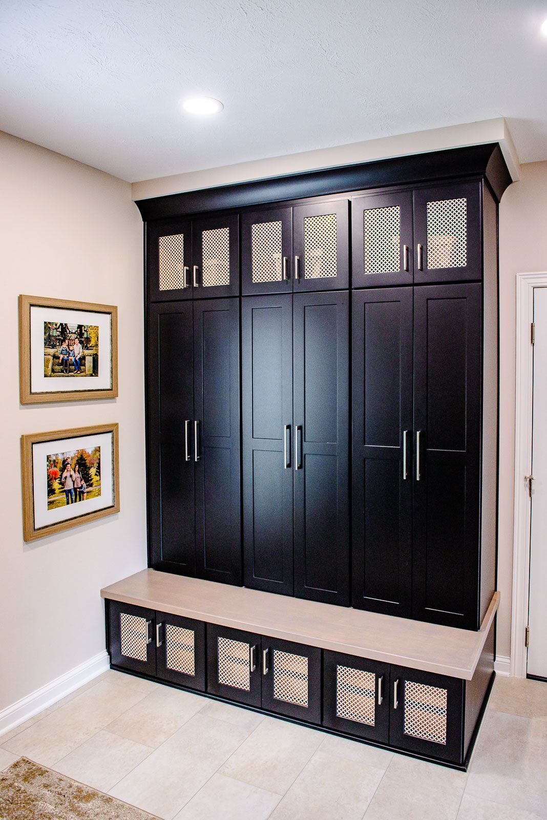A hallway with black cabinets and pictures on the wall
